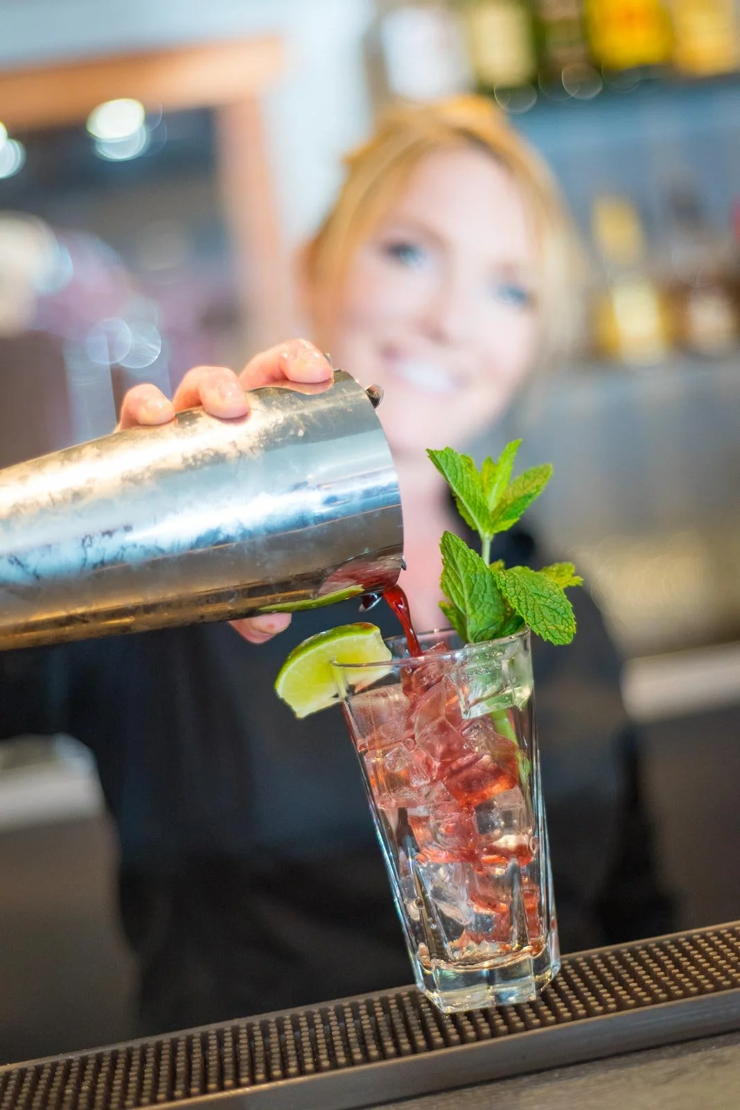Bartender pouring cocktail at bar, Nova Scotia branding photography