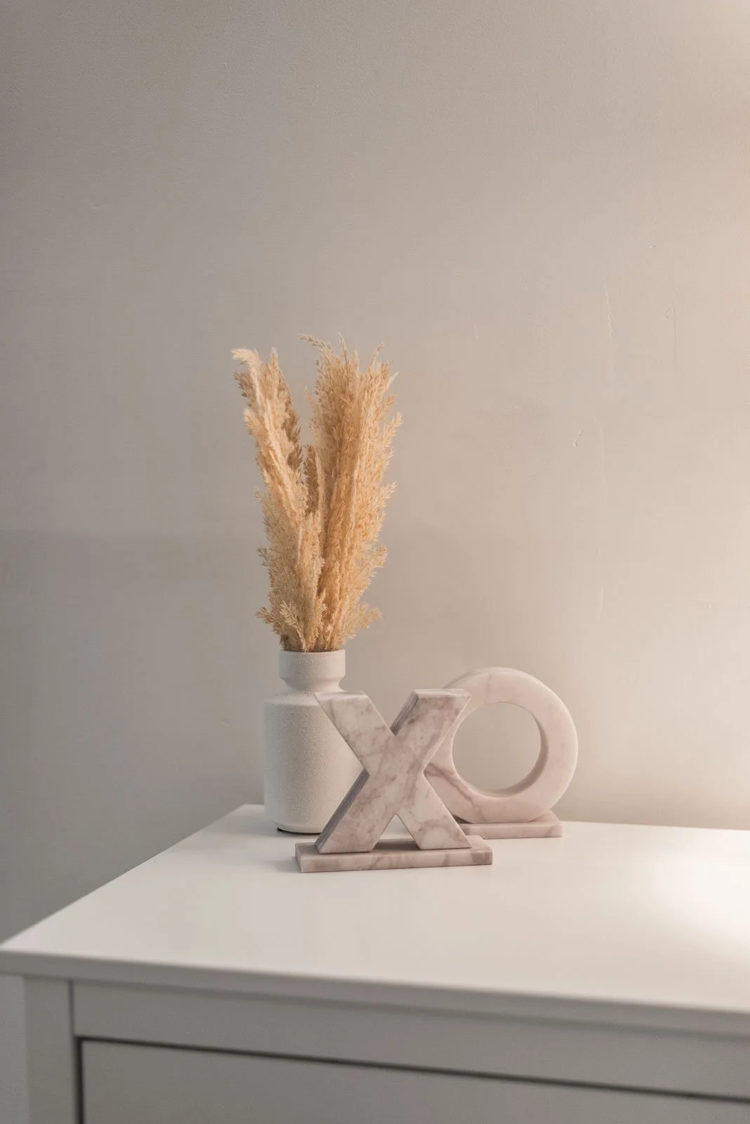 Decorative vase with dried grass and marble XO, interior branding photography