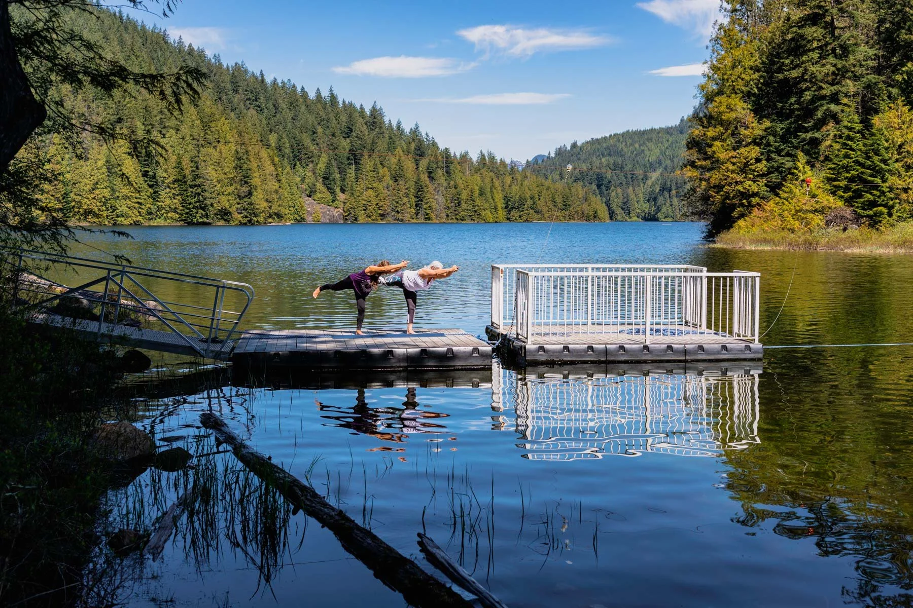 Two women doing yoga on a dock by lake, yoga retreat photographer nova scotia