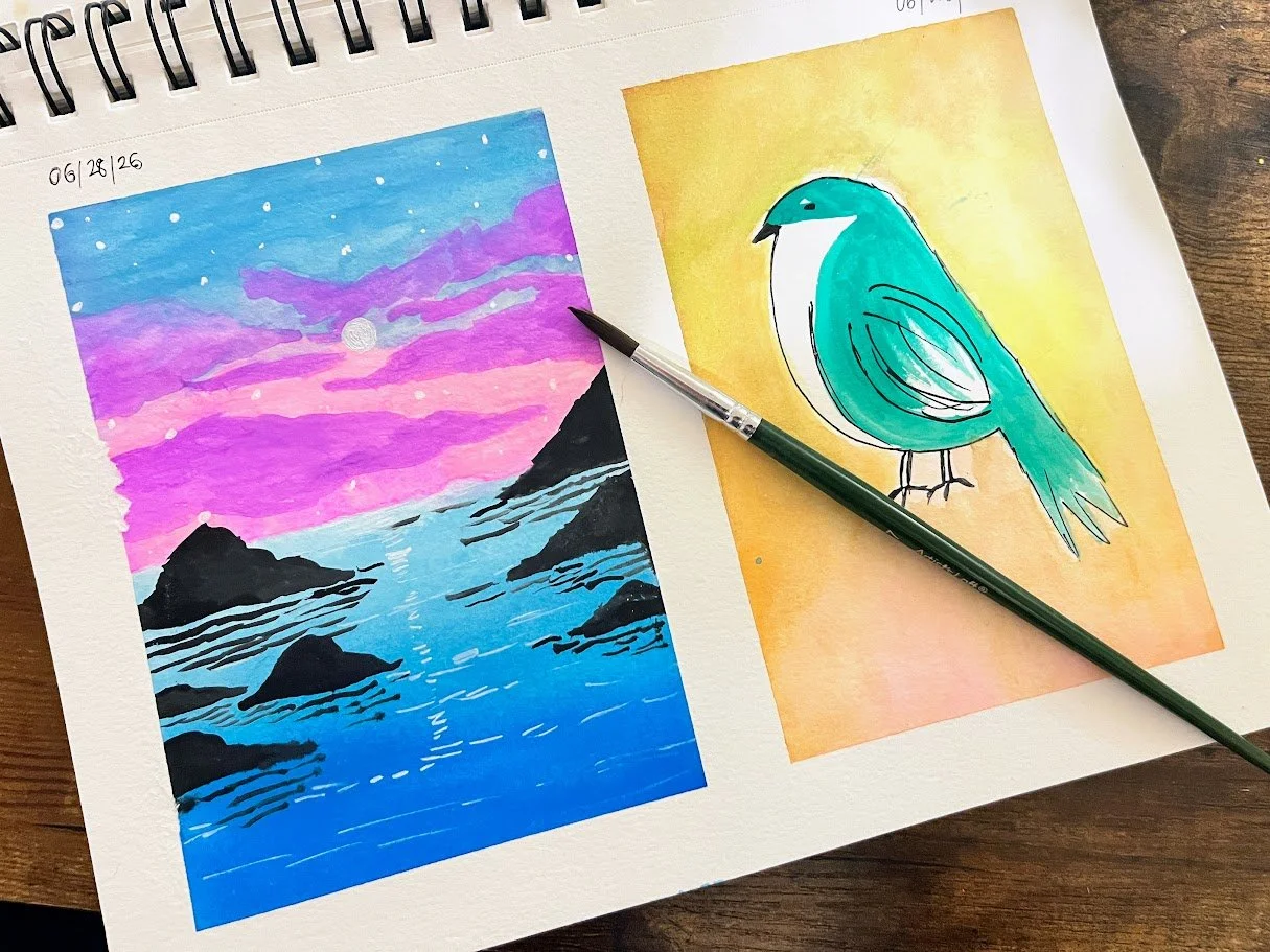 Two watercolor paintings on a sketchbook page, one of a sunset over a rocky shoreline with pink, purple, and blue sky and the other of a teal bird on an orange background, with a black pen resting on the page.
