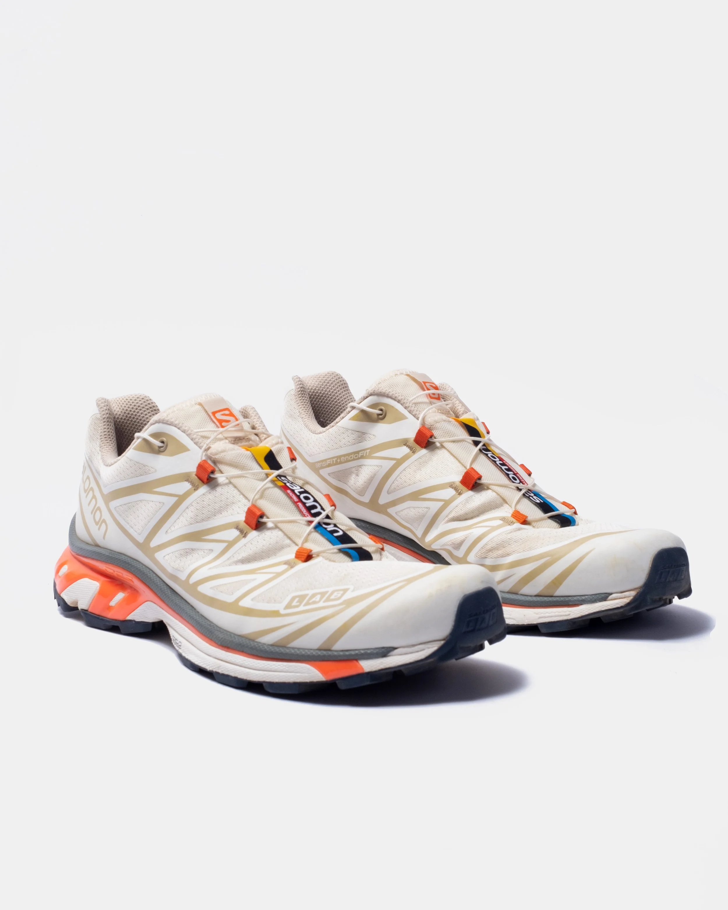 A pair of salomon xt6 running shoes with black soles, white laces, and a mesh upper, positioned on a white background.