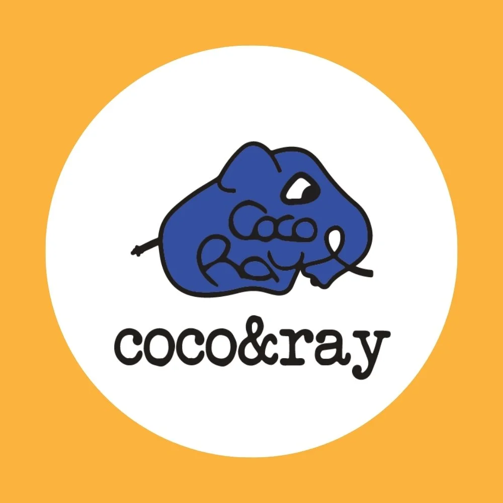 A logo featuring a stylized blue rock with the words "coco & ray" below it, set against a white circle on an orange background.