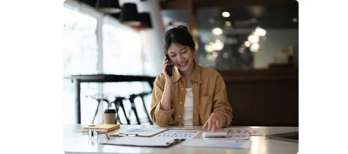 A Chinese business contact checking WeChat on her phone at her desk
