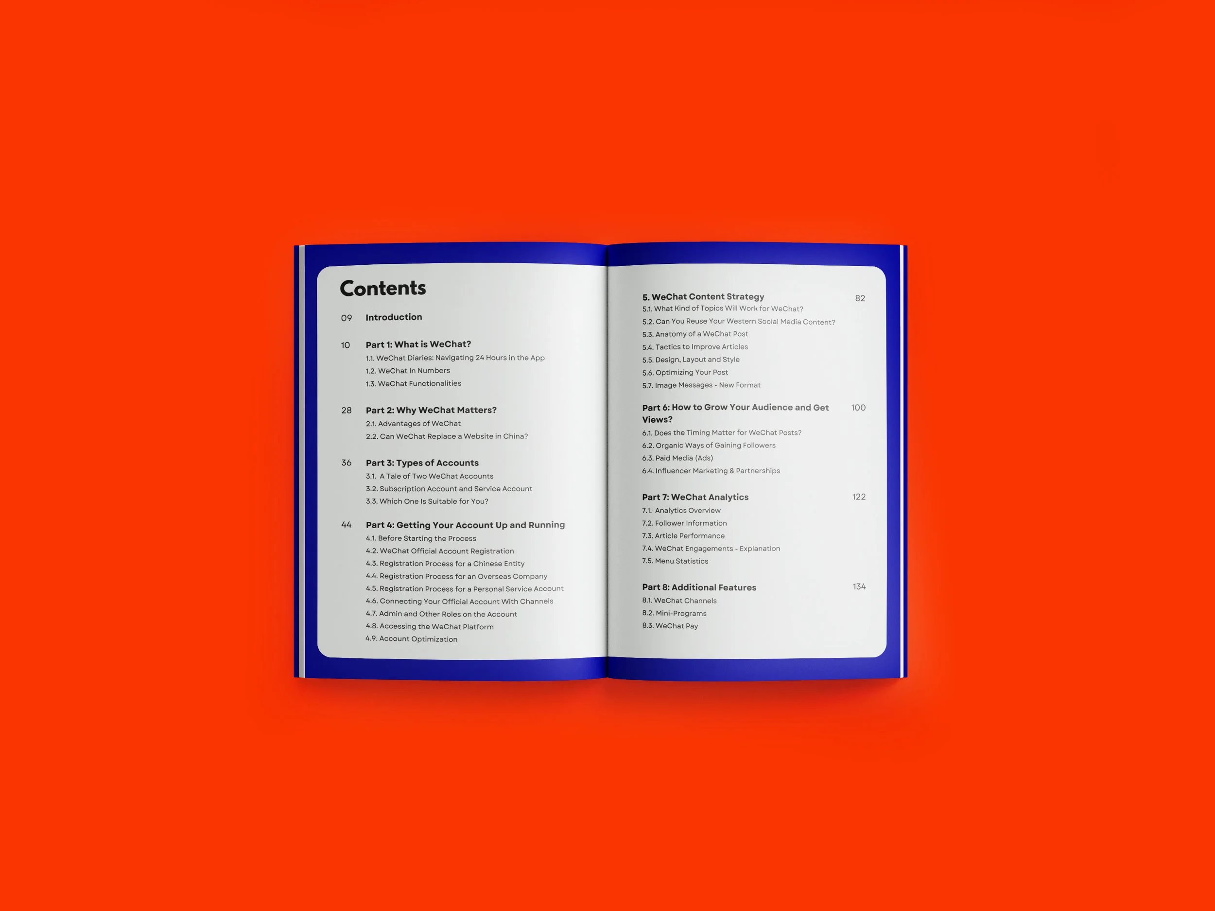 Open book with a blue cover displaying table of contents on white pages, laid on a red background.