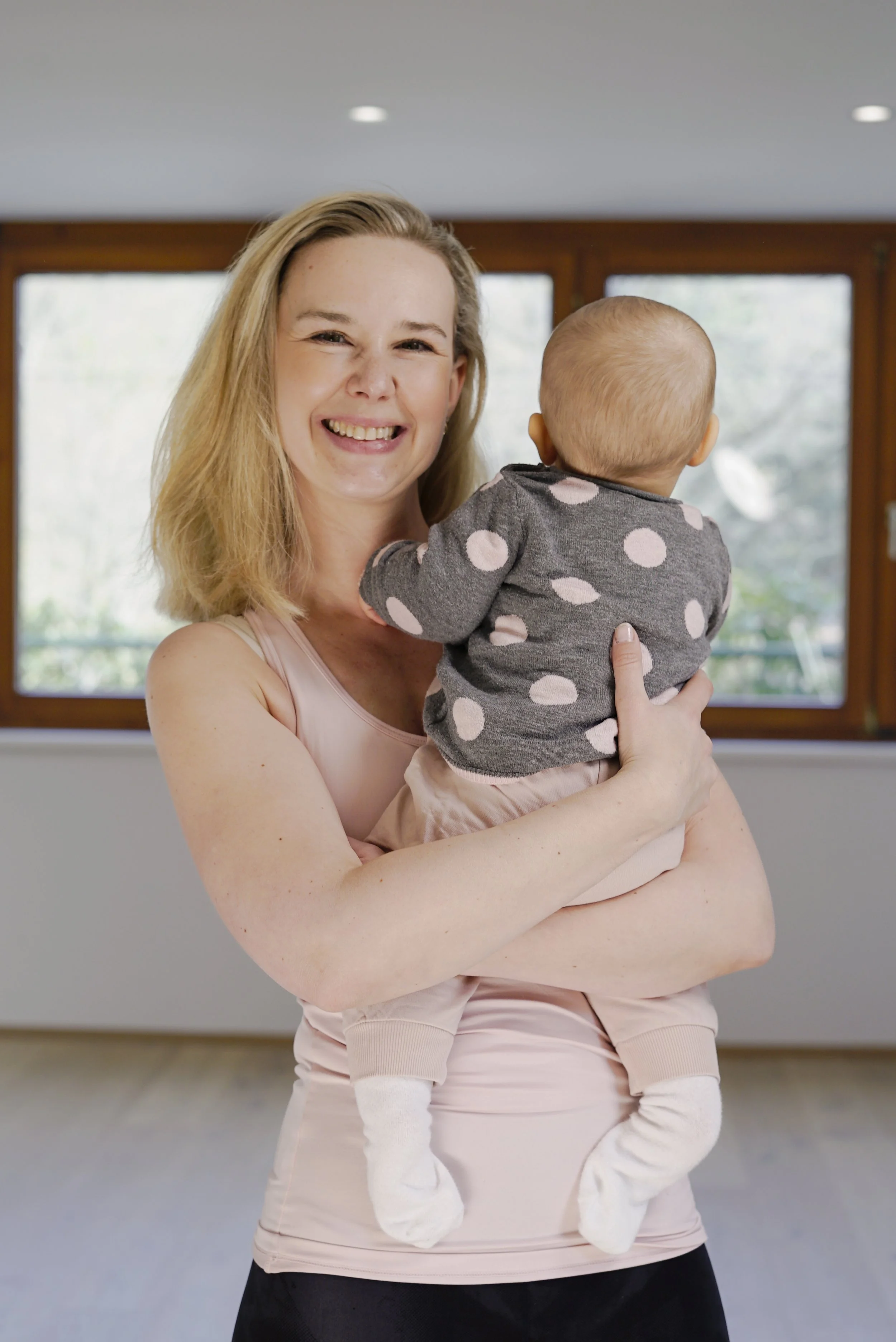 Mama mit Baby im Arm im Yogastudio