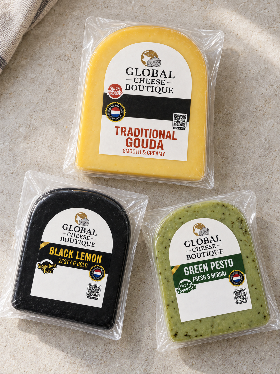 Traditional Gouda, Black Lemon and Green Pesto in sealed retail packs on a light stone surface.