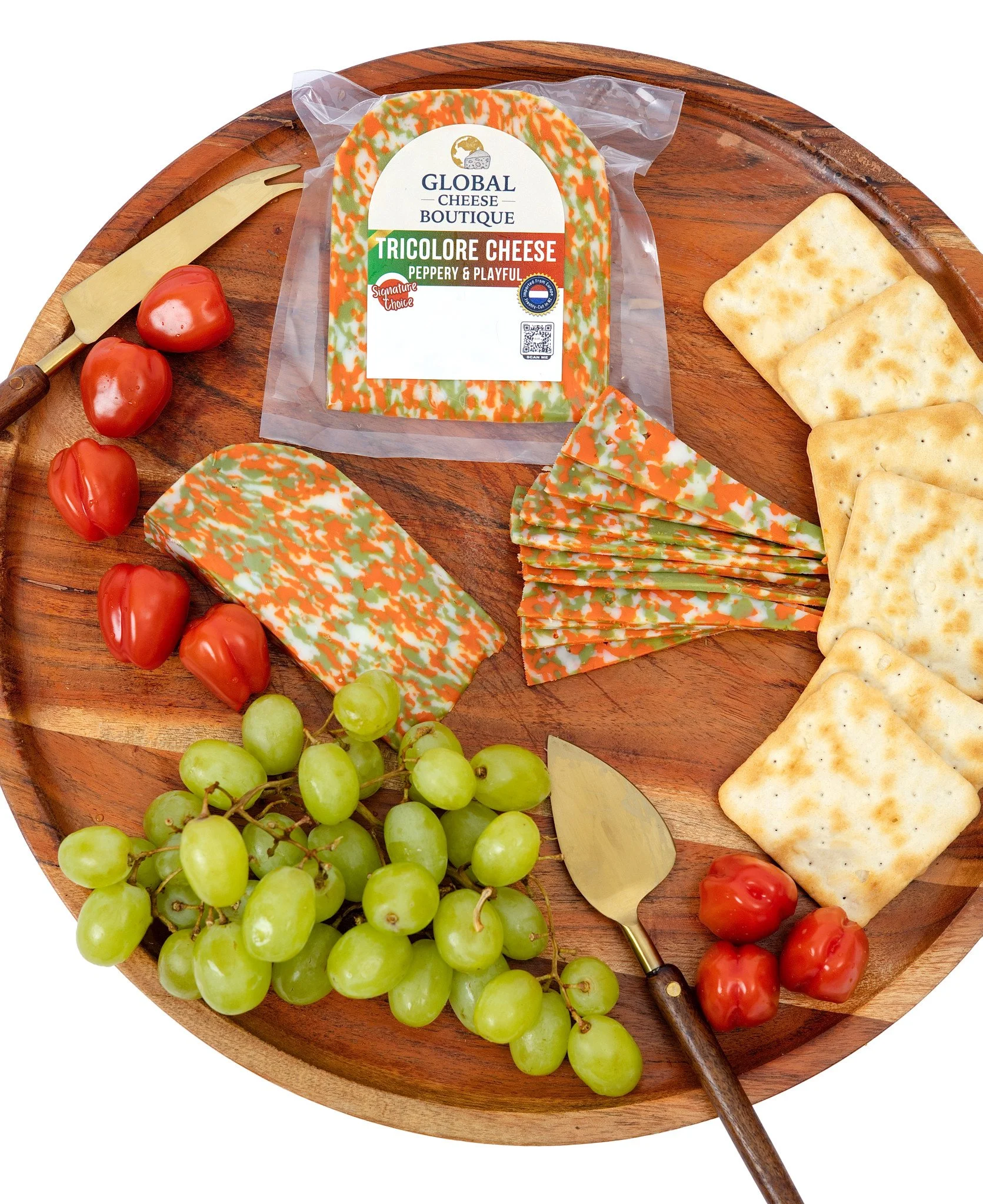 Tricolore Gouda 180 g, sealed pack, wedge and slices on a round wooden tray with tomatoes and crackers
