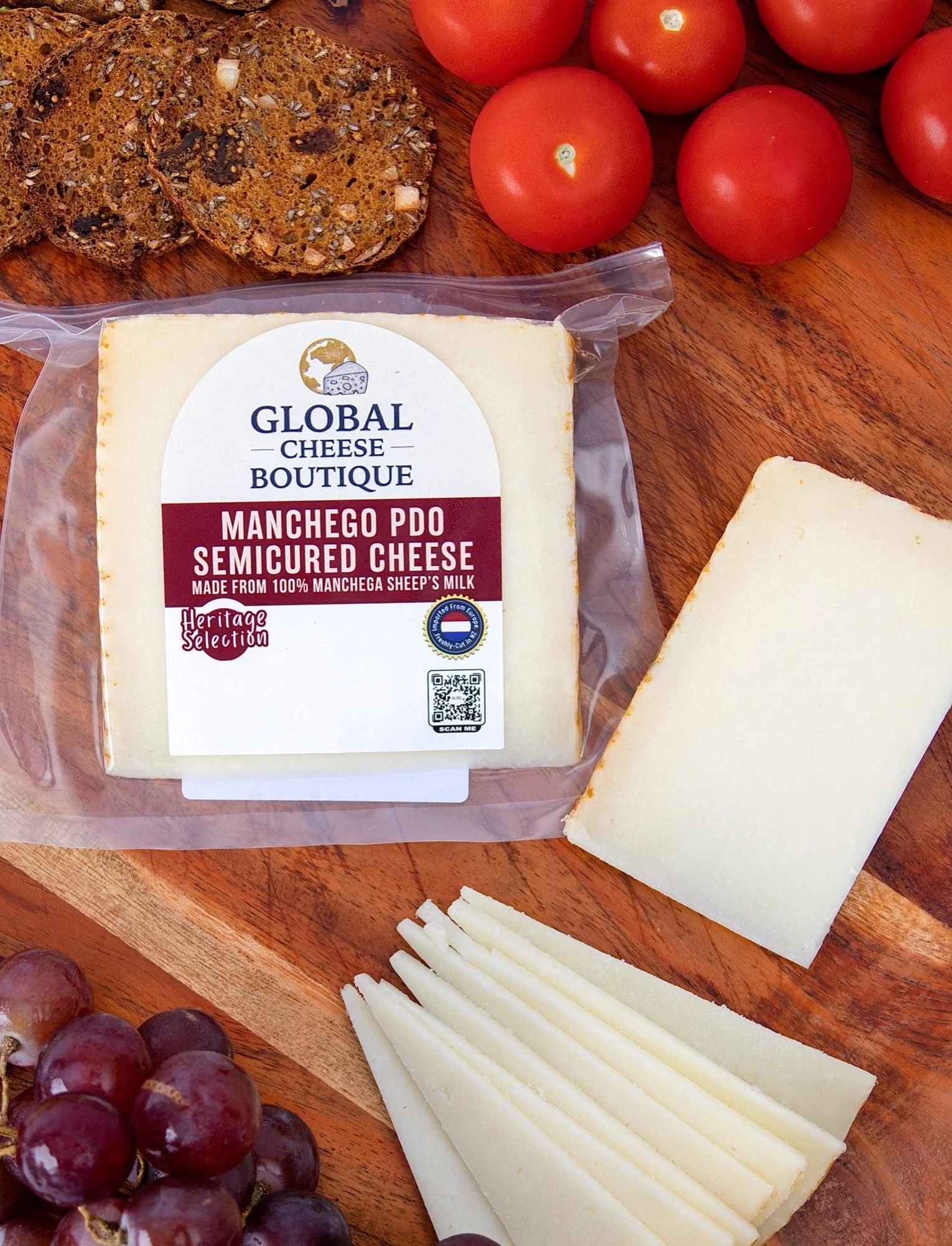 Spanish Manchego 140 g from above with seeded crackers, cherry tomatoes and slices