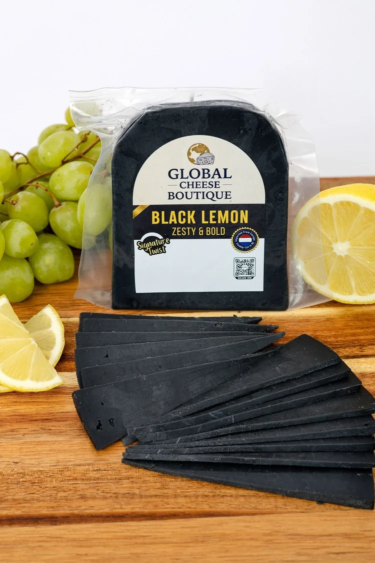 Black Lemon Gouda 180 g, sealed pack with slices, lemon and grapes on a board