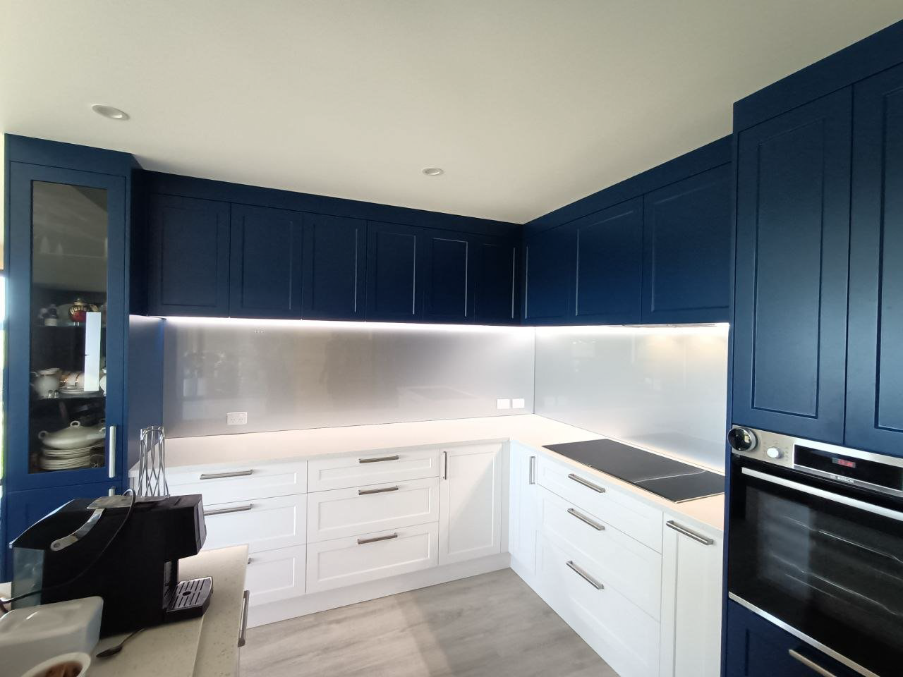 A custom glass splashback featured in the kitchen of a home.
