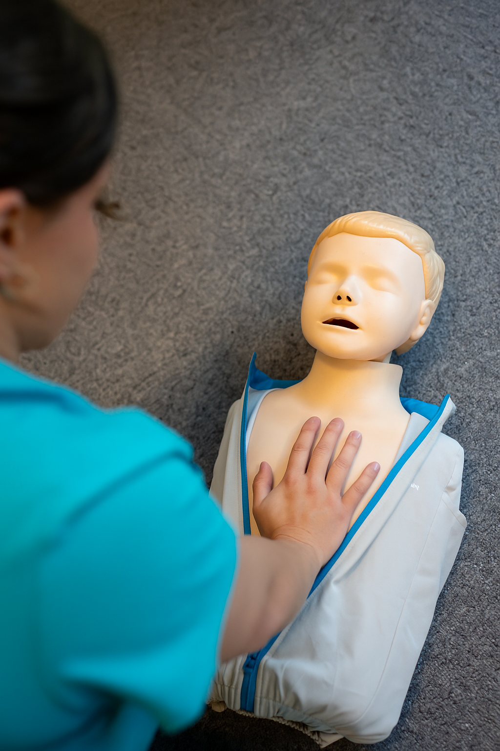 Tri Medics Training staff performing CPR on a mannequin lying on the ground