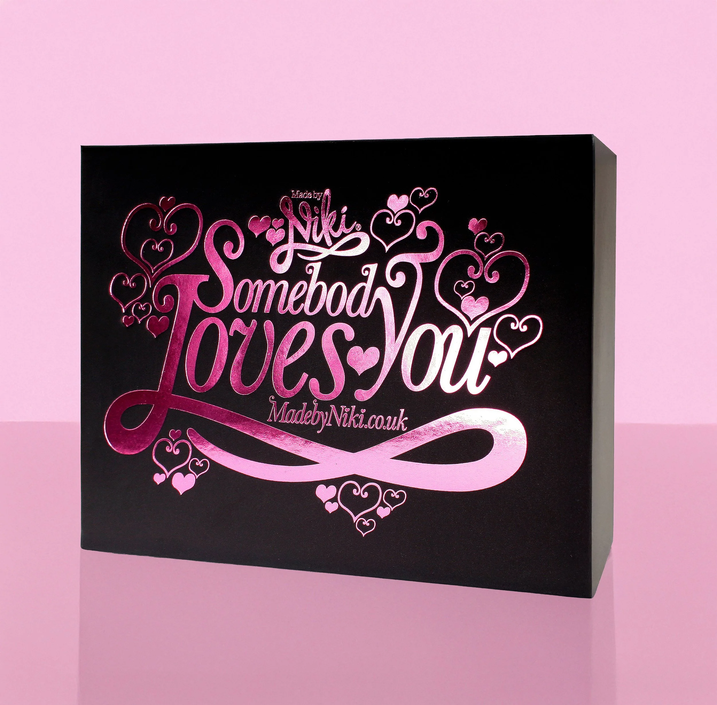 Black box with pink and white text that reads 'Made by Niki, Somebody Loves You, MadebyNiki.co.uk' and surrounded by pink and white hearts on a pink background.