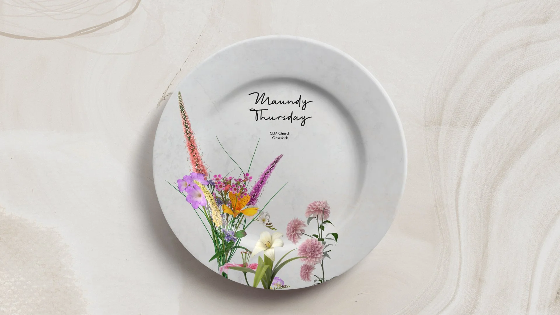 White ceramic plate on a beige marble surface with a floral design featuring purple, pink, and yellow flowers on the lower left side. The plate has black handwritten text that reads 'Maundy Thursday' and additional smaller text below that says 'CLM Church Ormskirk'.