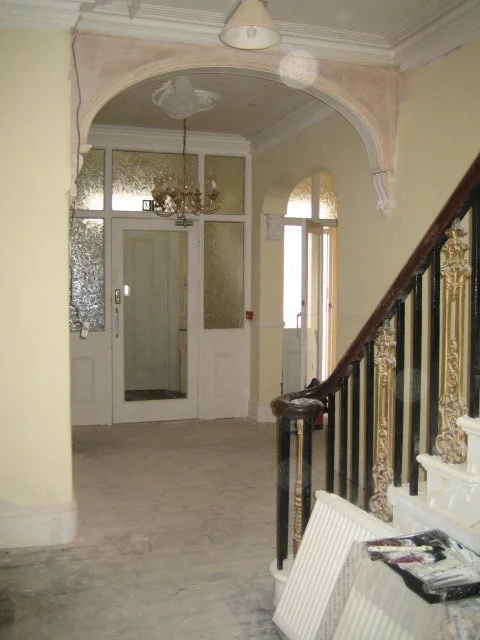 Hotel interior in Great Yarmouth with staircase, decorative archway, and entrance doors during renovation