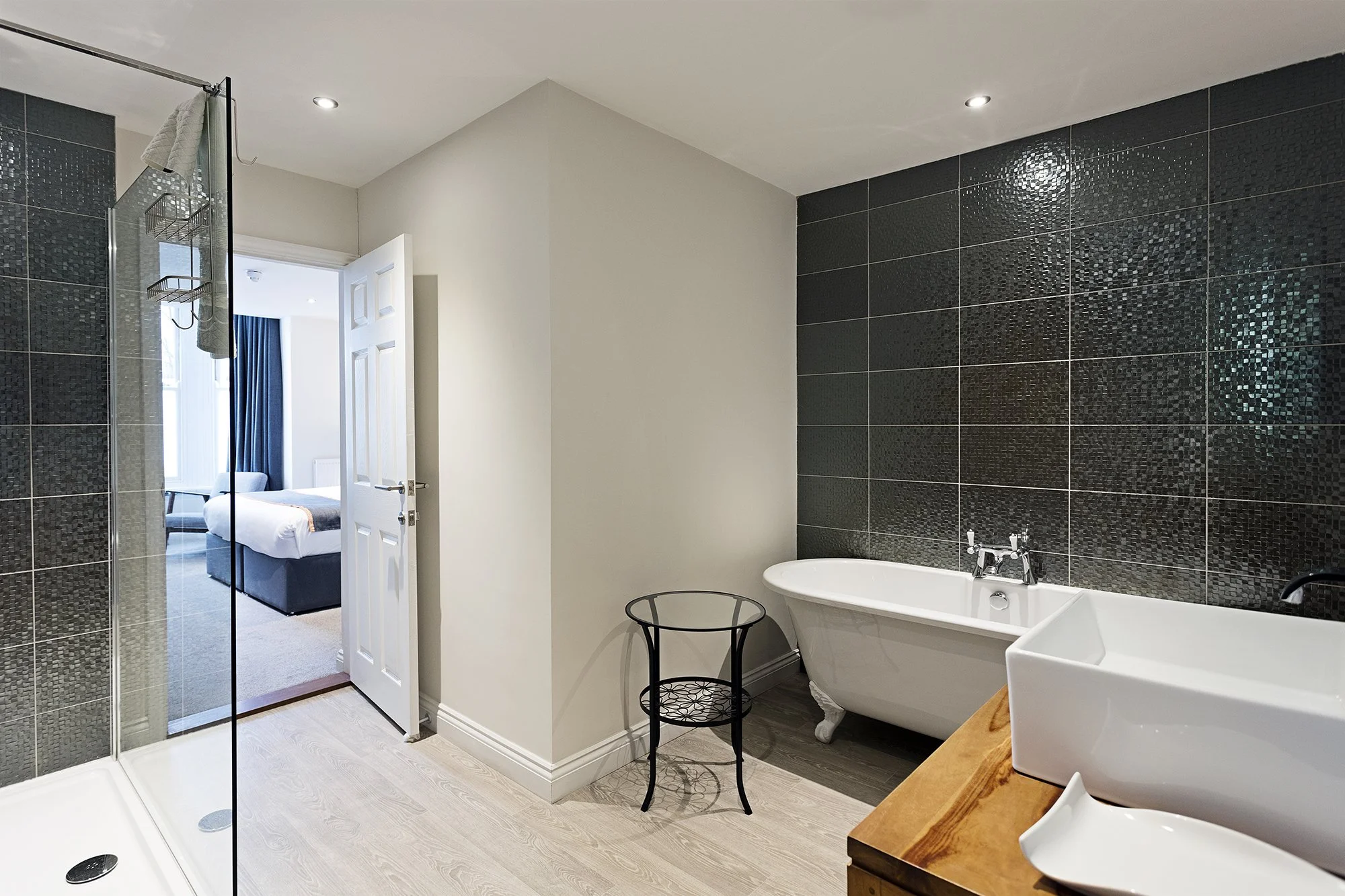 Hotel room bathroom with bathtub, walk-in shower leading through to a bedroom at Andover House hotel in Great Yarmouth