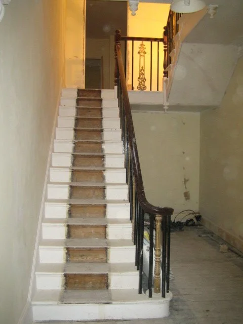 Renovation of hotel interior in Great Yarmouth featuring a white staircase with exposed wooden steps and decorative landing railing