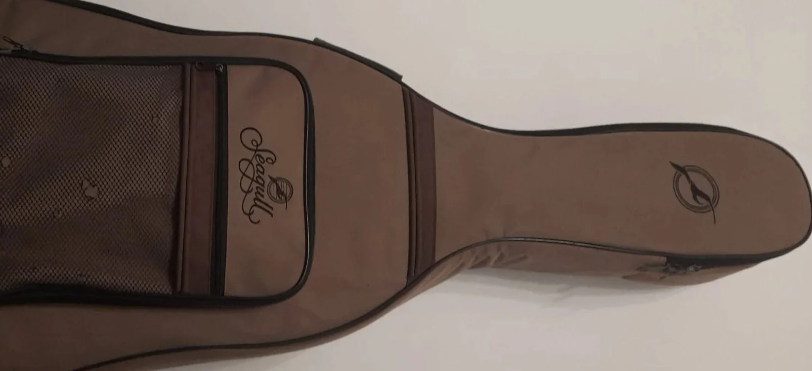 A beige golf bag with the brand Pearl Logo and a front zippered pocket.