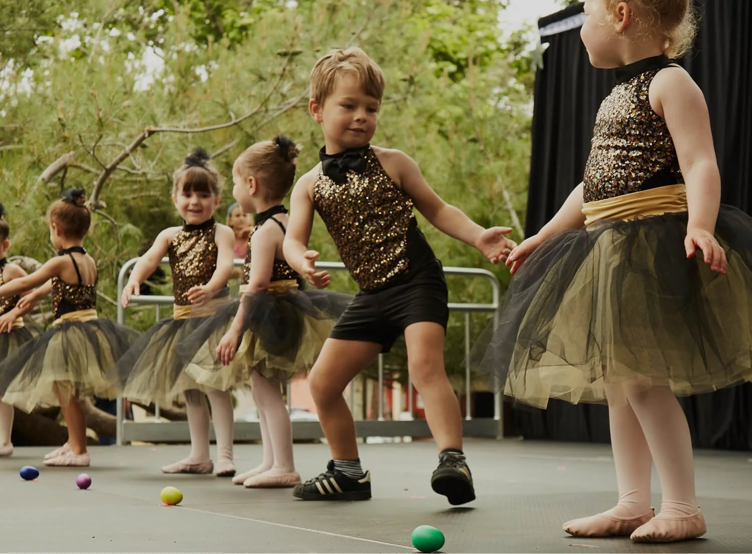 Students of Dance with Miss Alice performing in matching glittery black and gold costumes.