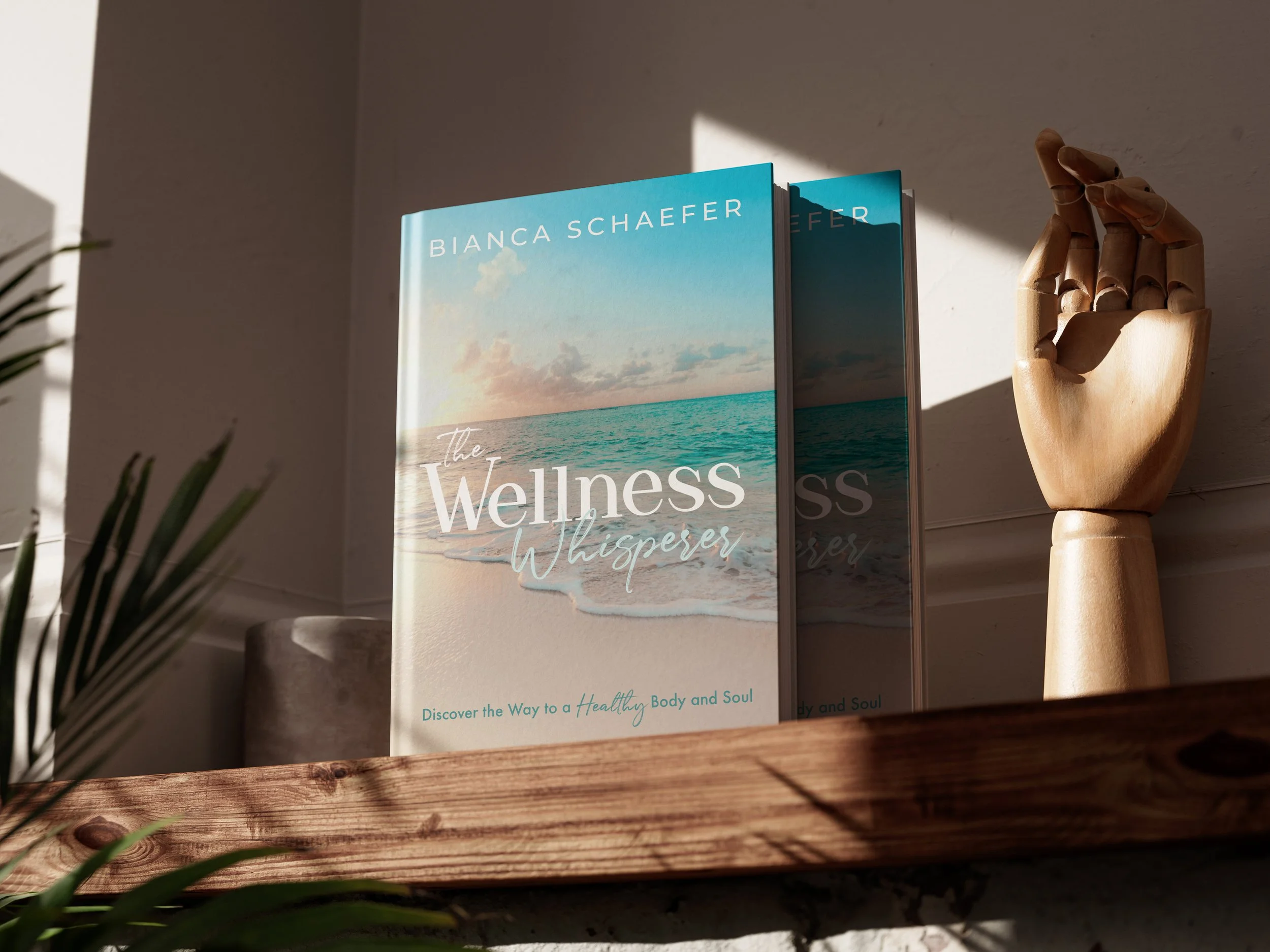 'The Wellness Whisperer' by Bianca Schaefer on a wooden shelf.