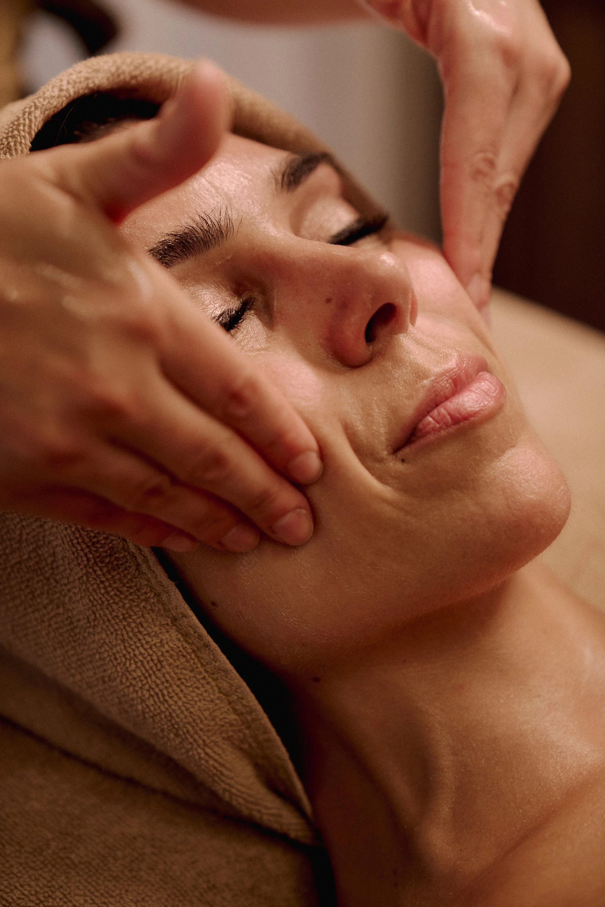 mulher a receber uma massagem e drenagem facial para ficar com o rosto contornado, desinchado e com a pele mais luminosa