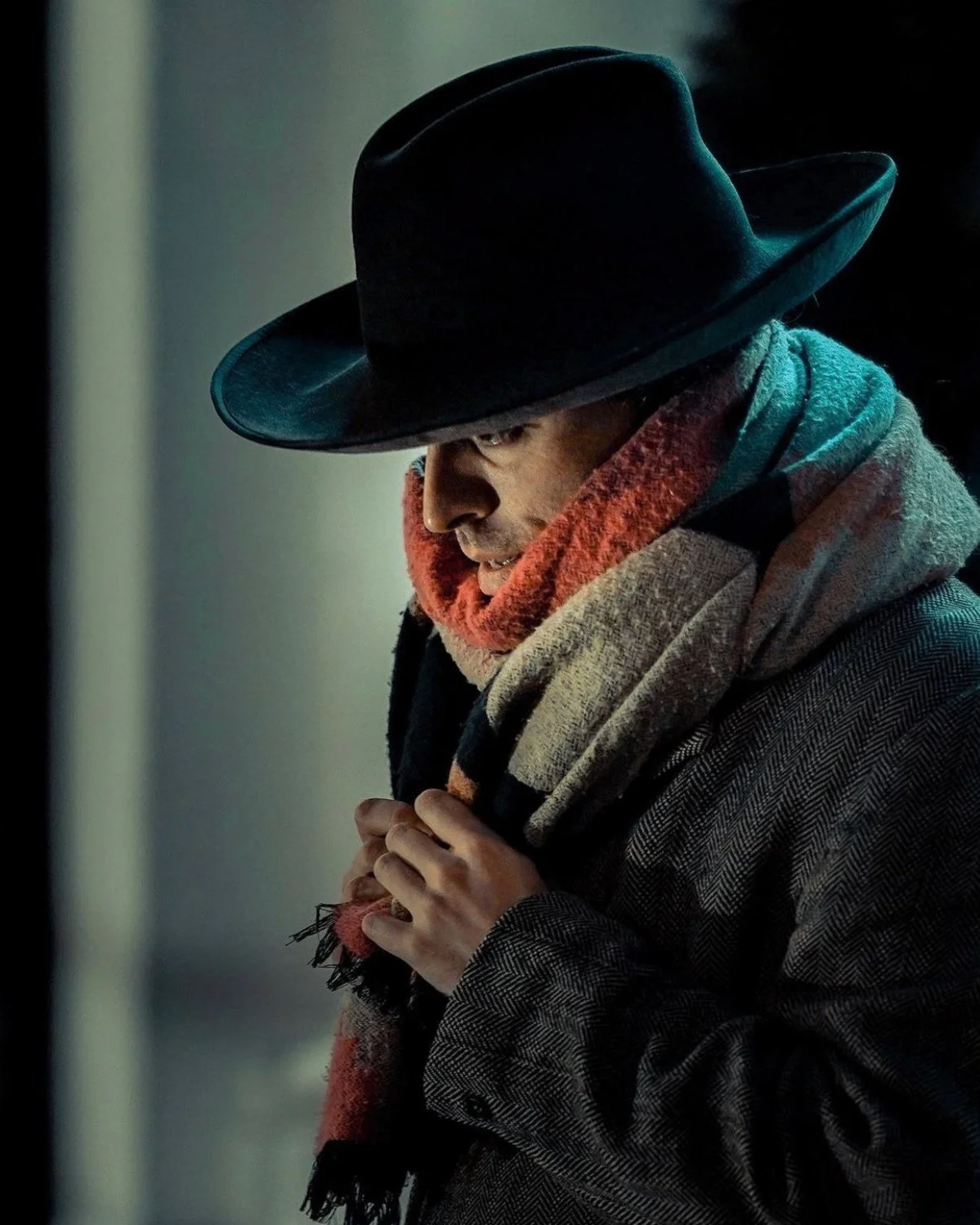 Moody street portrait of person in a dark hat and scarf, captured in soft light - Dublin photography.