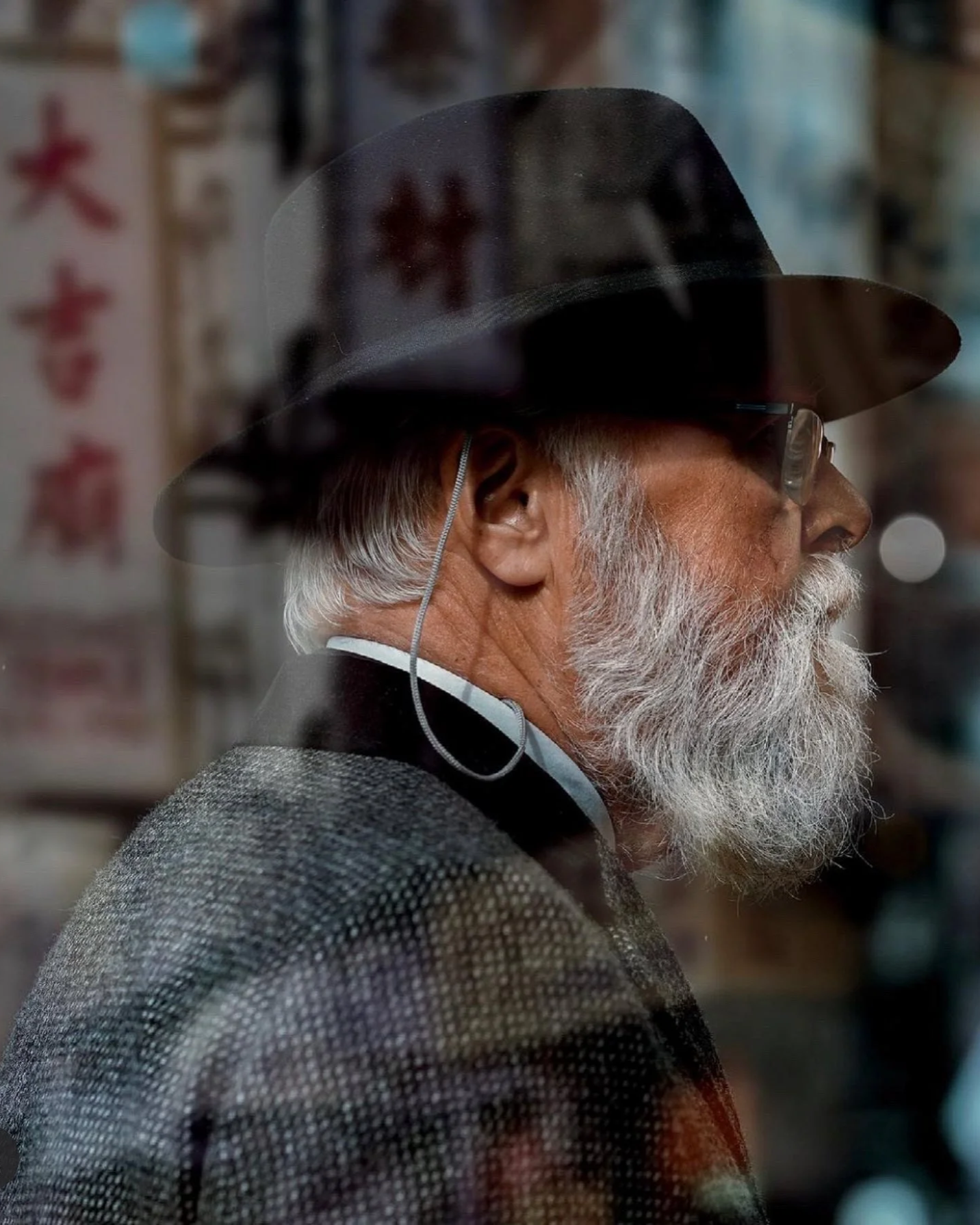 Candid Dublin street portrait of an older man with a white beard and black hat, captured in profile - Photo by Daniya, street Photography