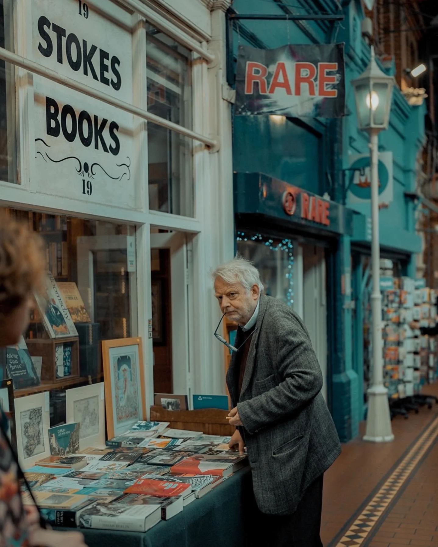 Candid scene at Stokes Books: older man browsing rare books on a city street — Dublin street photography, Photo by Daniya.