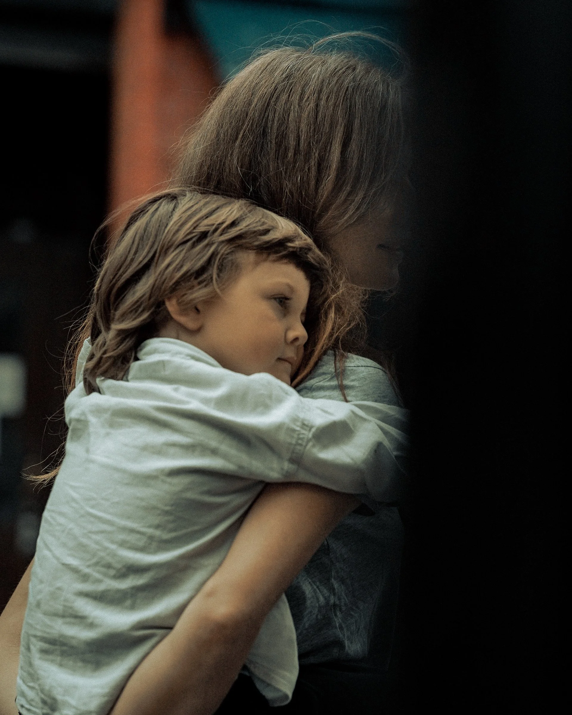 Tender moment of a child resting on a woman’s shoulder, candid street scene — Dublin street photography, Photo by Daniya.