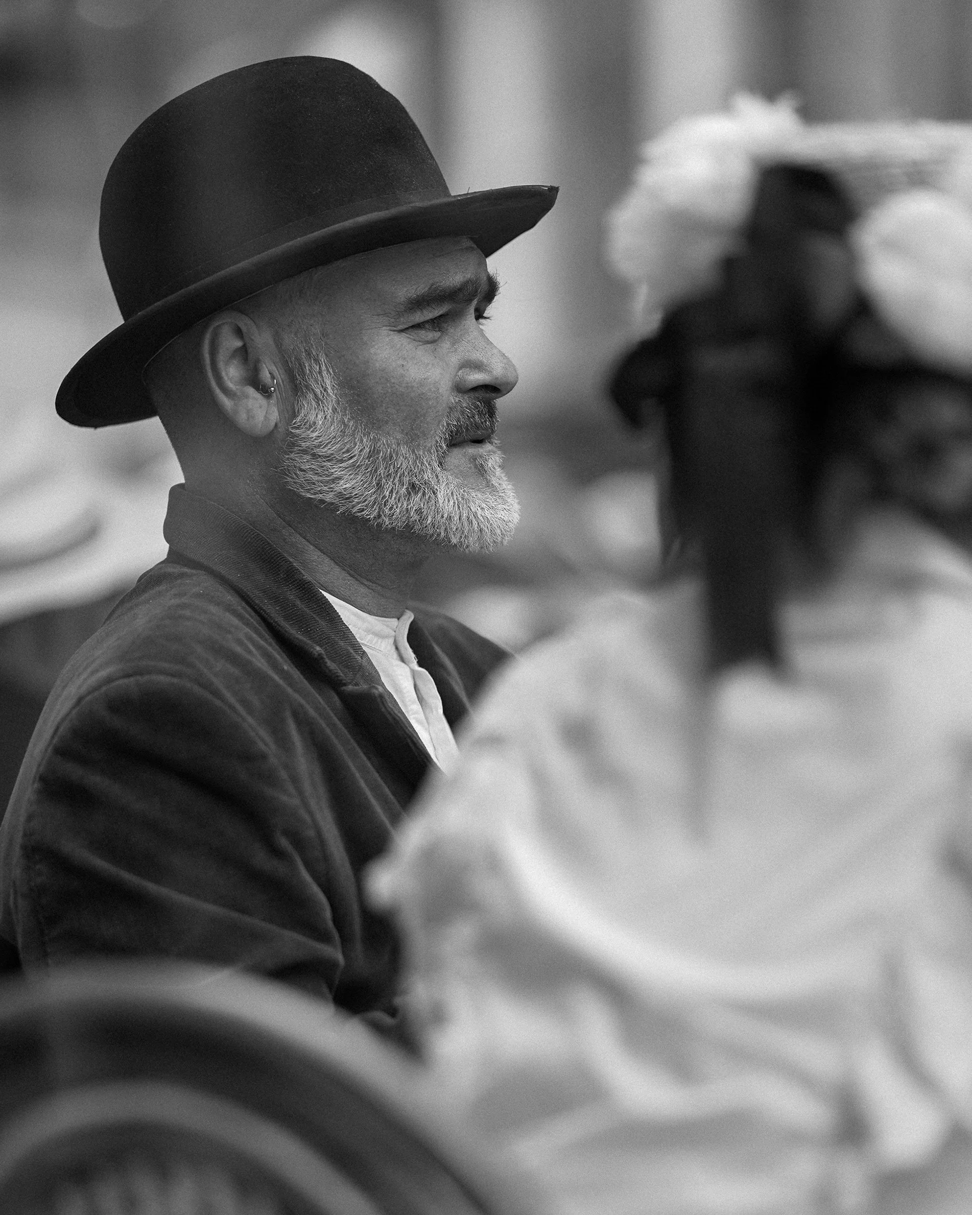 Black and white street portrait of a man in a bowler hat with a beard, side profile, Dublin documentary photography.