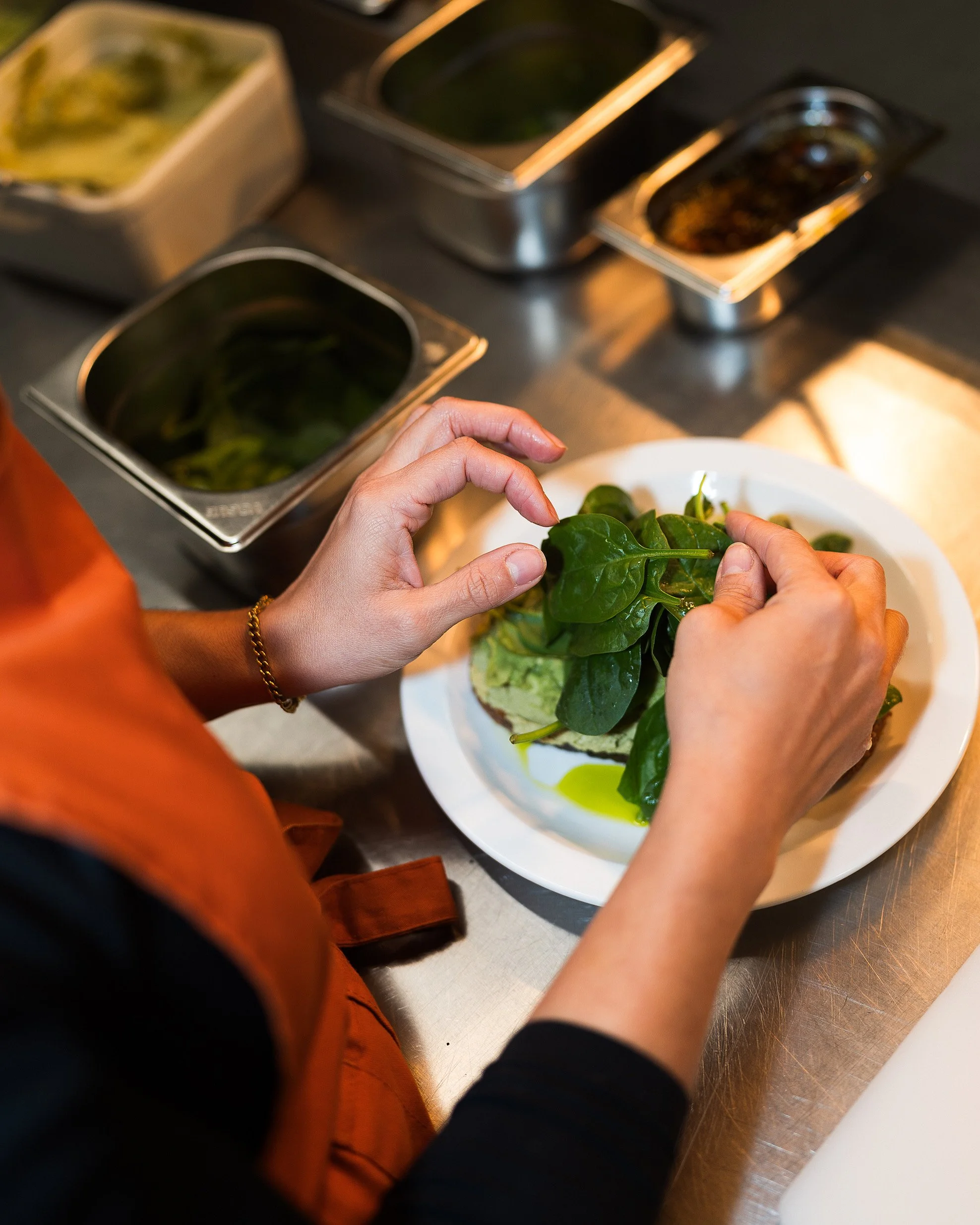 Chef preparing salad with fresh green leaves in Dublin café.