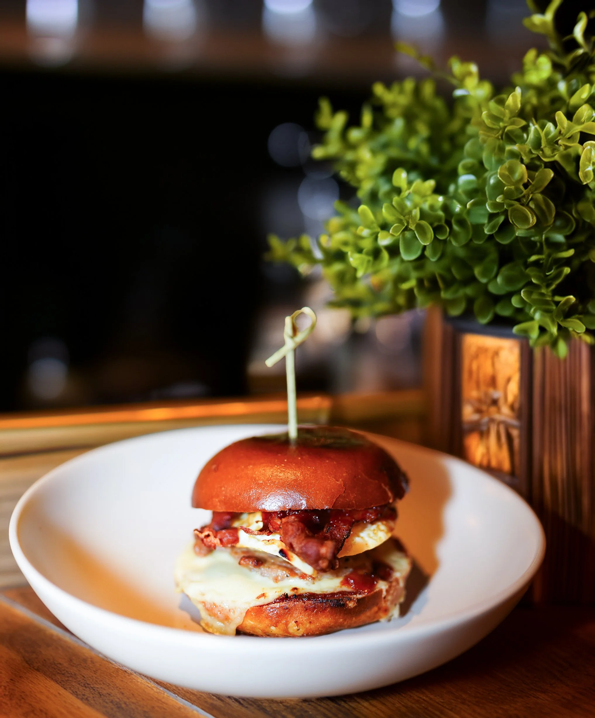 Gourmet burger with bacon and cheese on a white plate in Dublin restaurant.