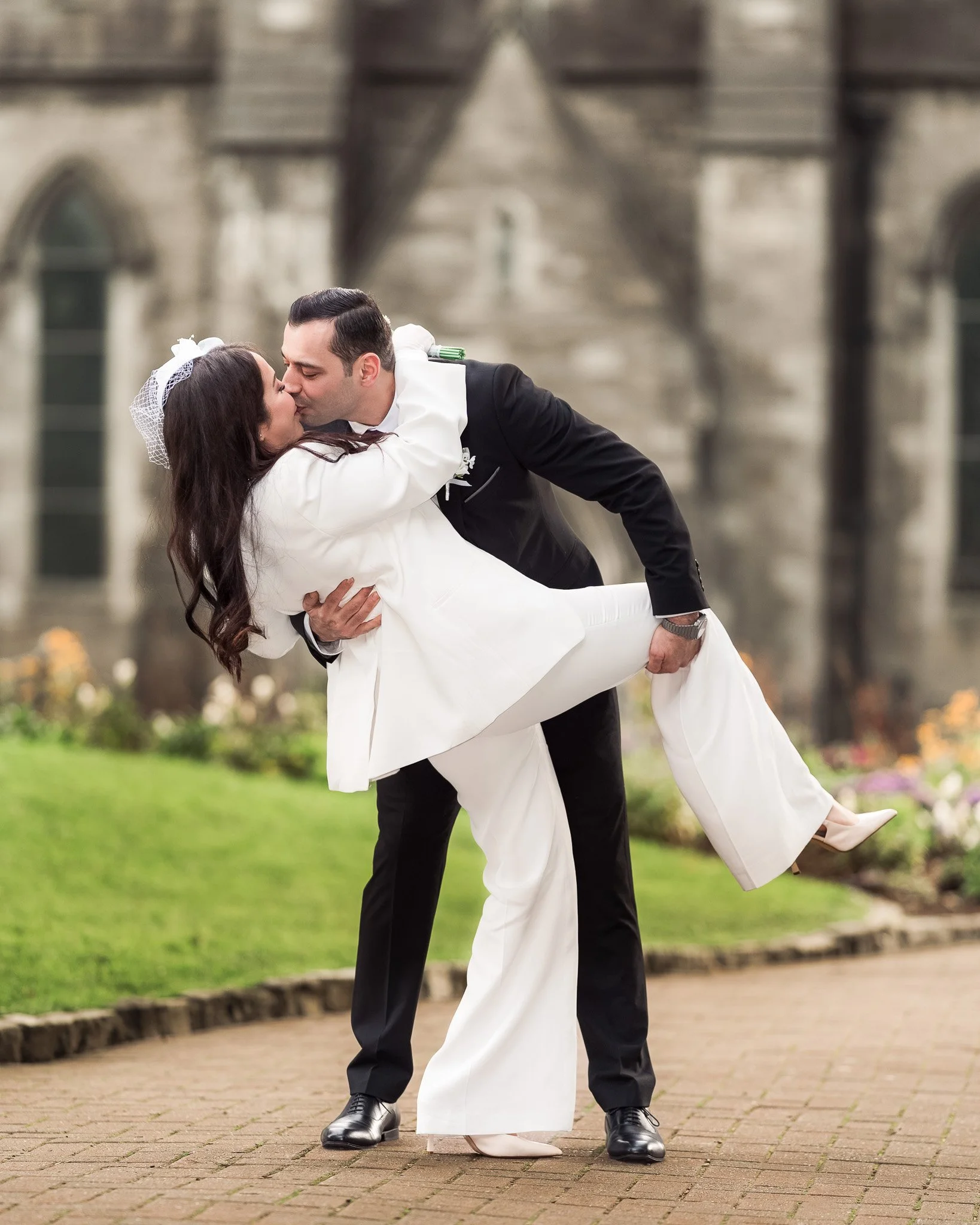 Groom gently holding his bride’s hand in a soft natural light, captured in Dublin gardens.