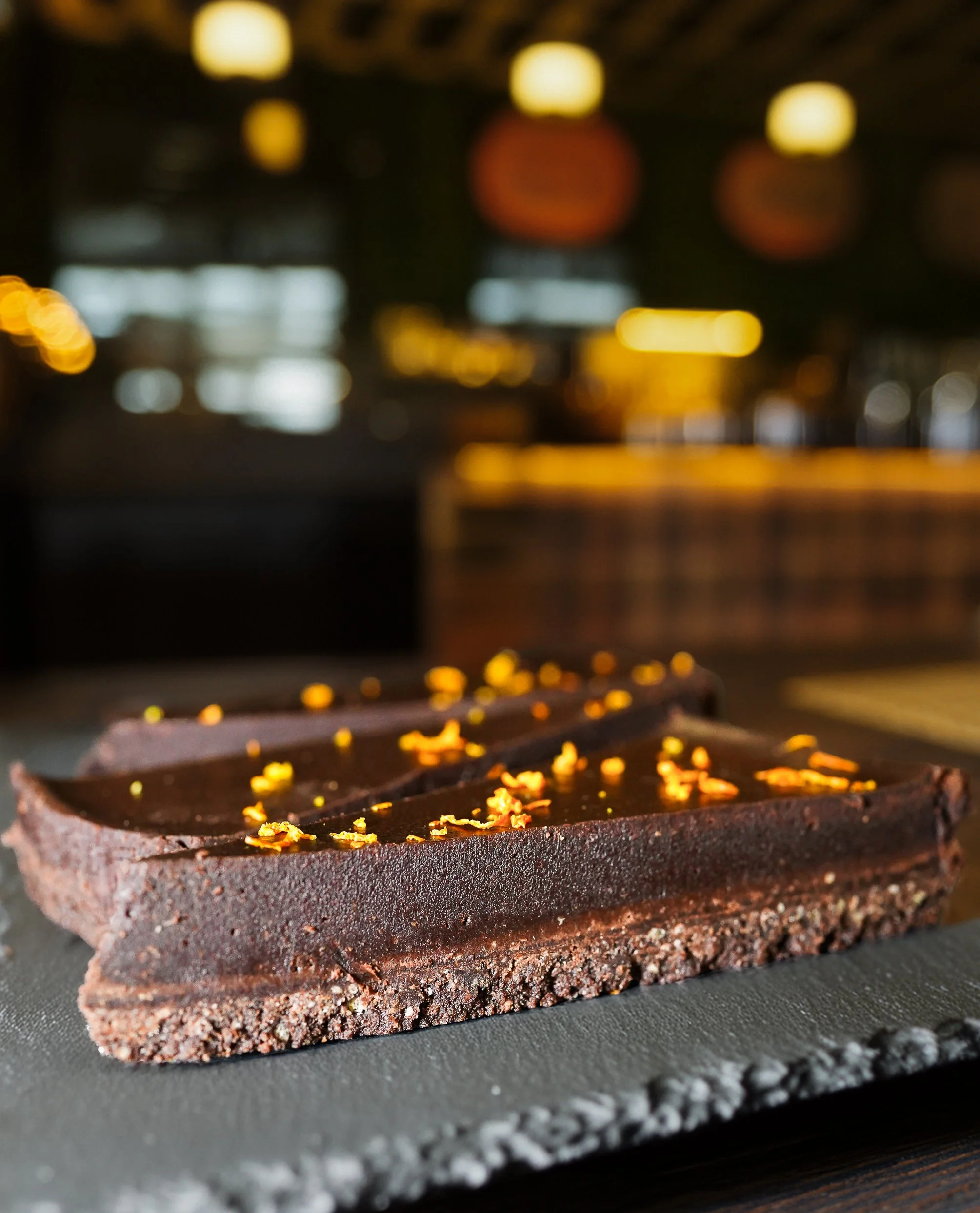 Chocolate dessert with nuts captured in elegant restaurant setting.