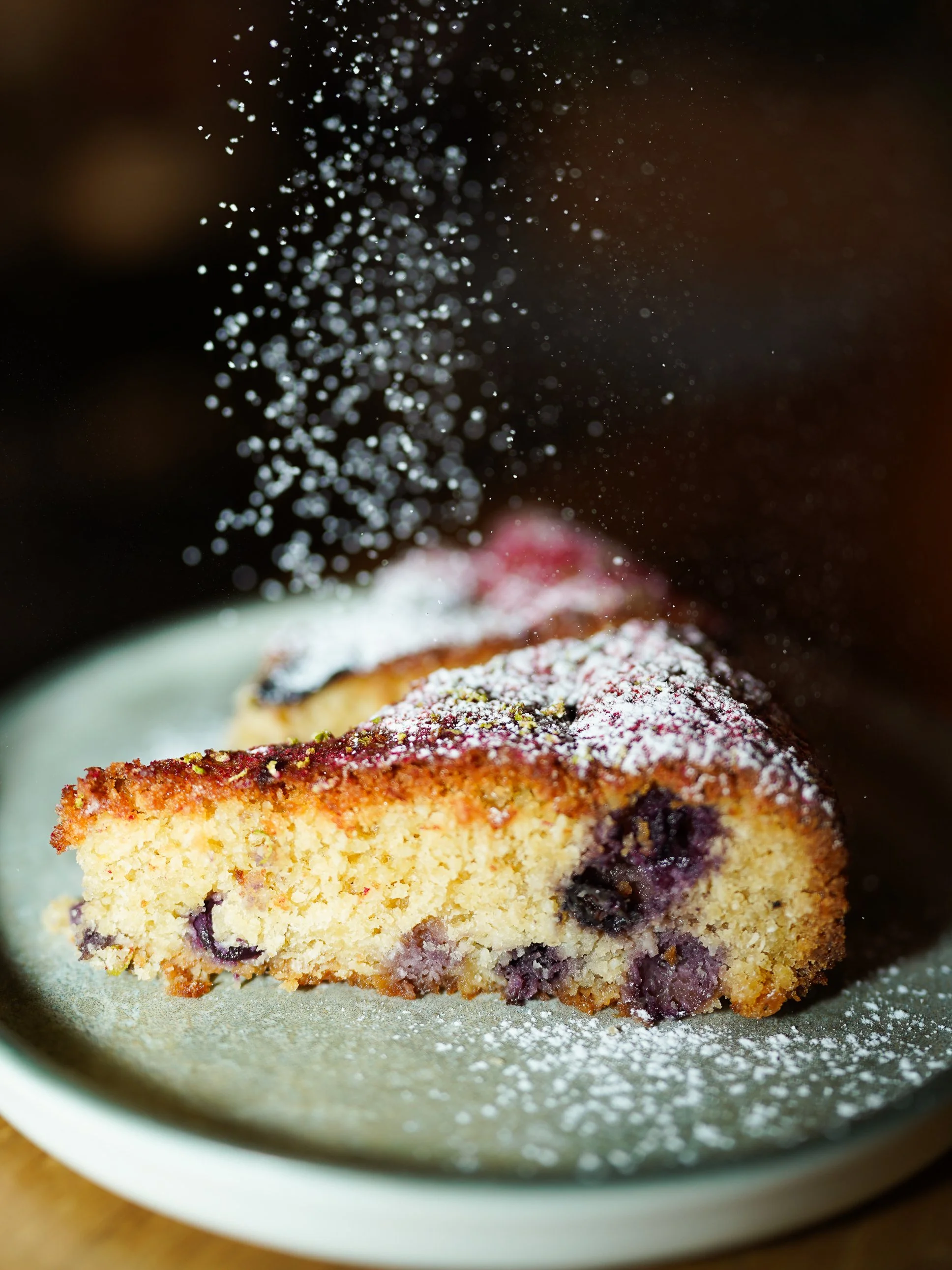 Slice of cherry cake sprinkled with powdered sugar.