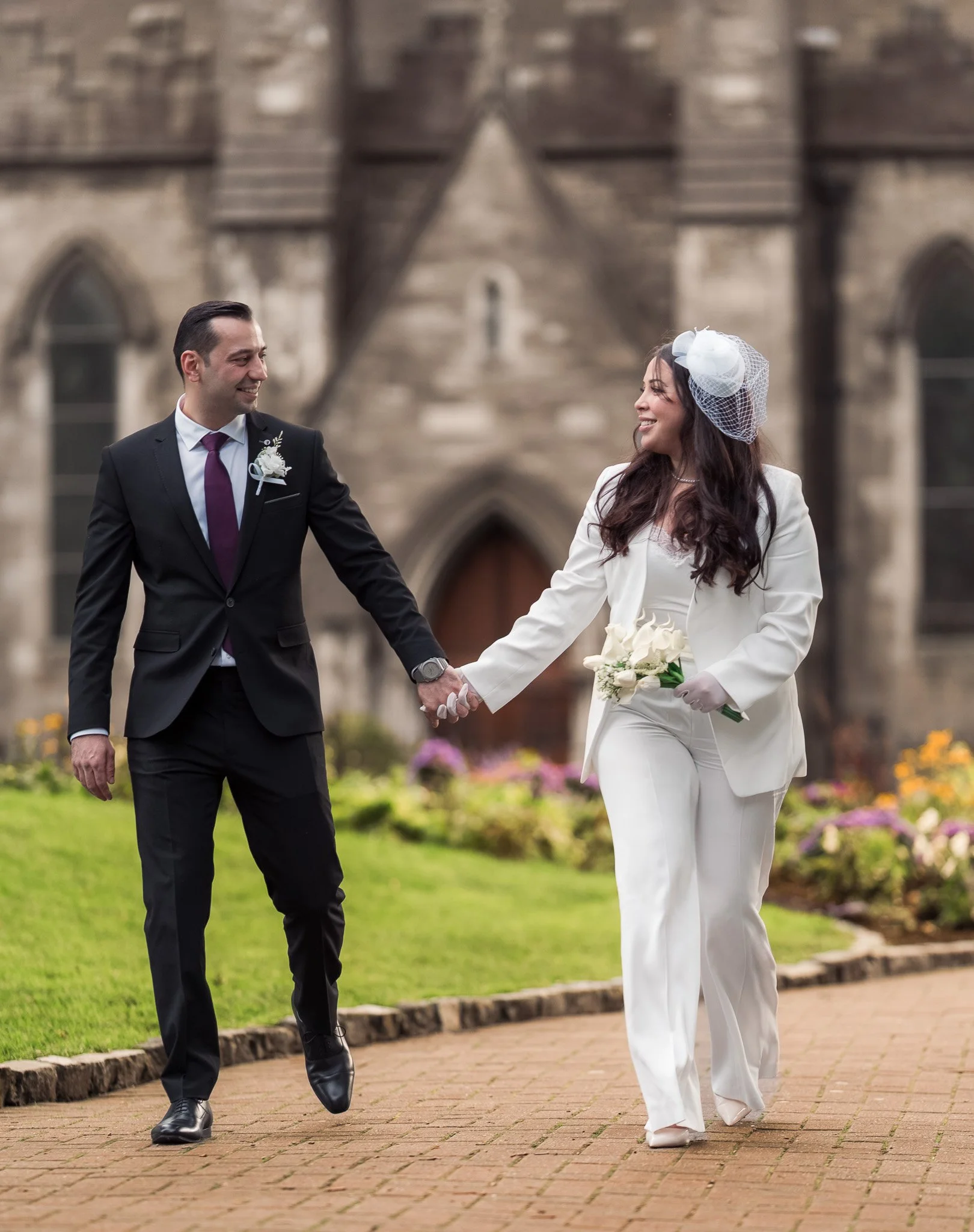 Bride and groom walking hand in hand near St. Patrick’s Cathedral, Dublin.