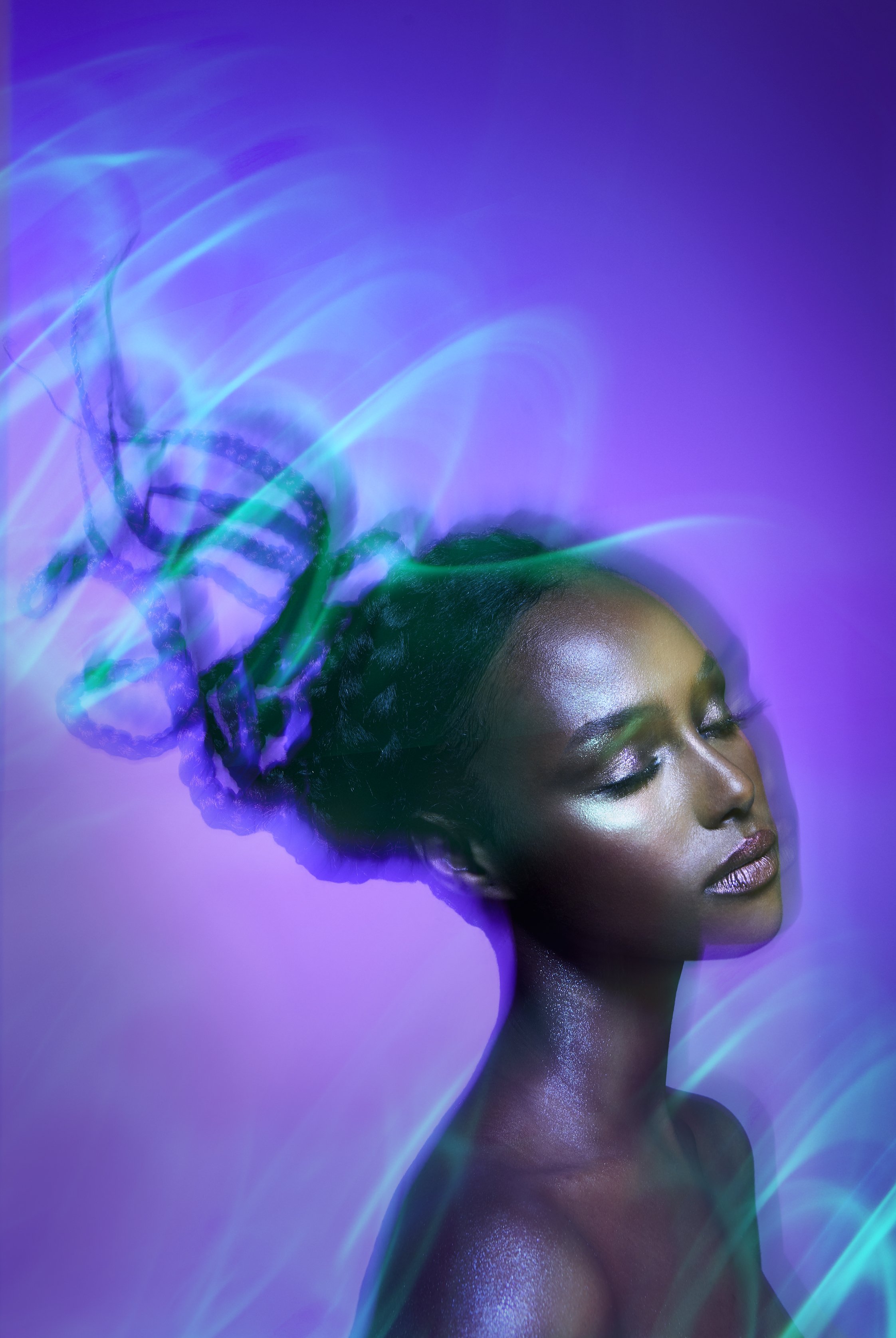 A cropped beauty image of a female model with silver makeup and purple background with light trails