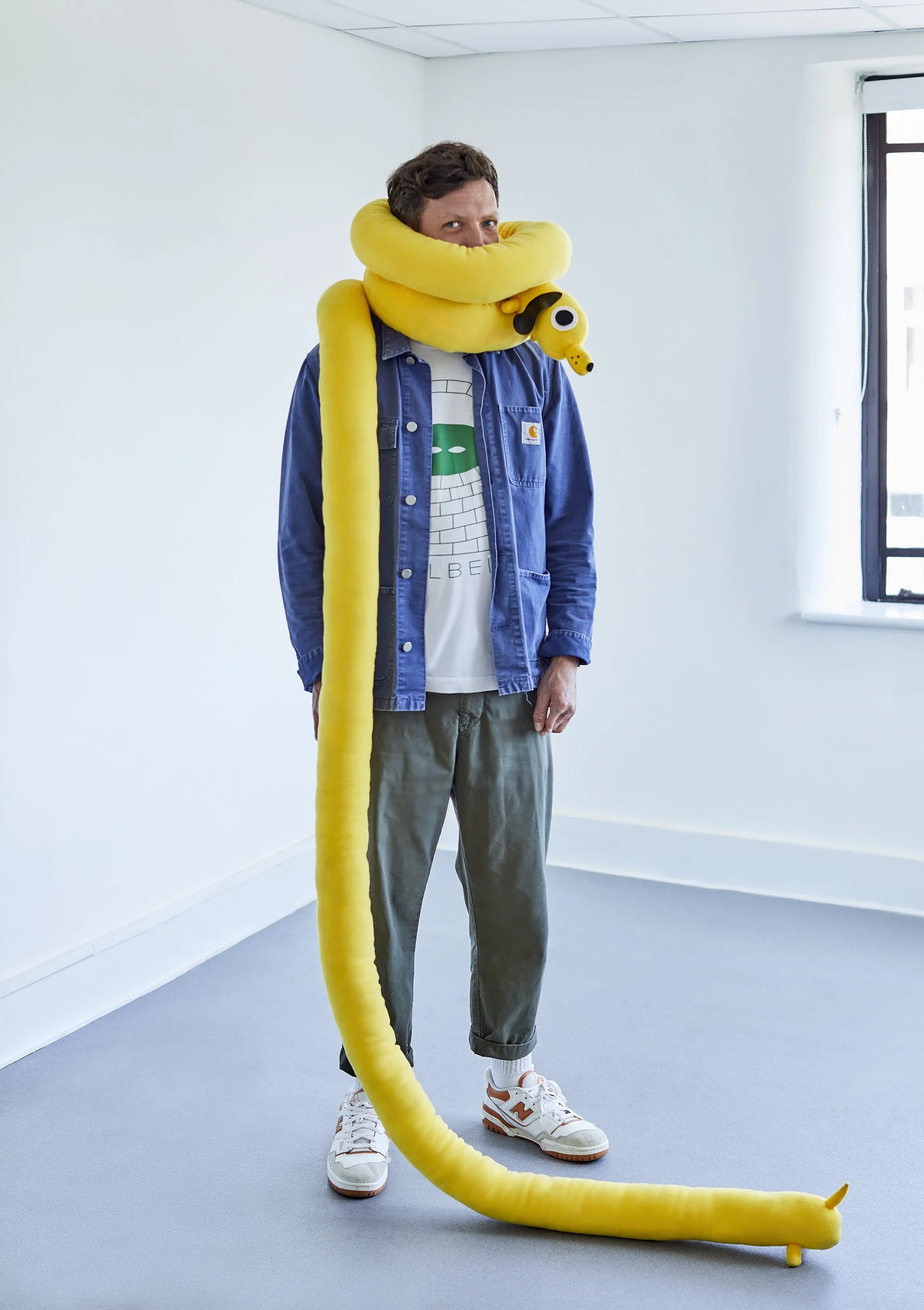 Portrait of white man with dark hair with toy dog wrapped around his neck