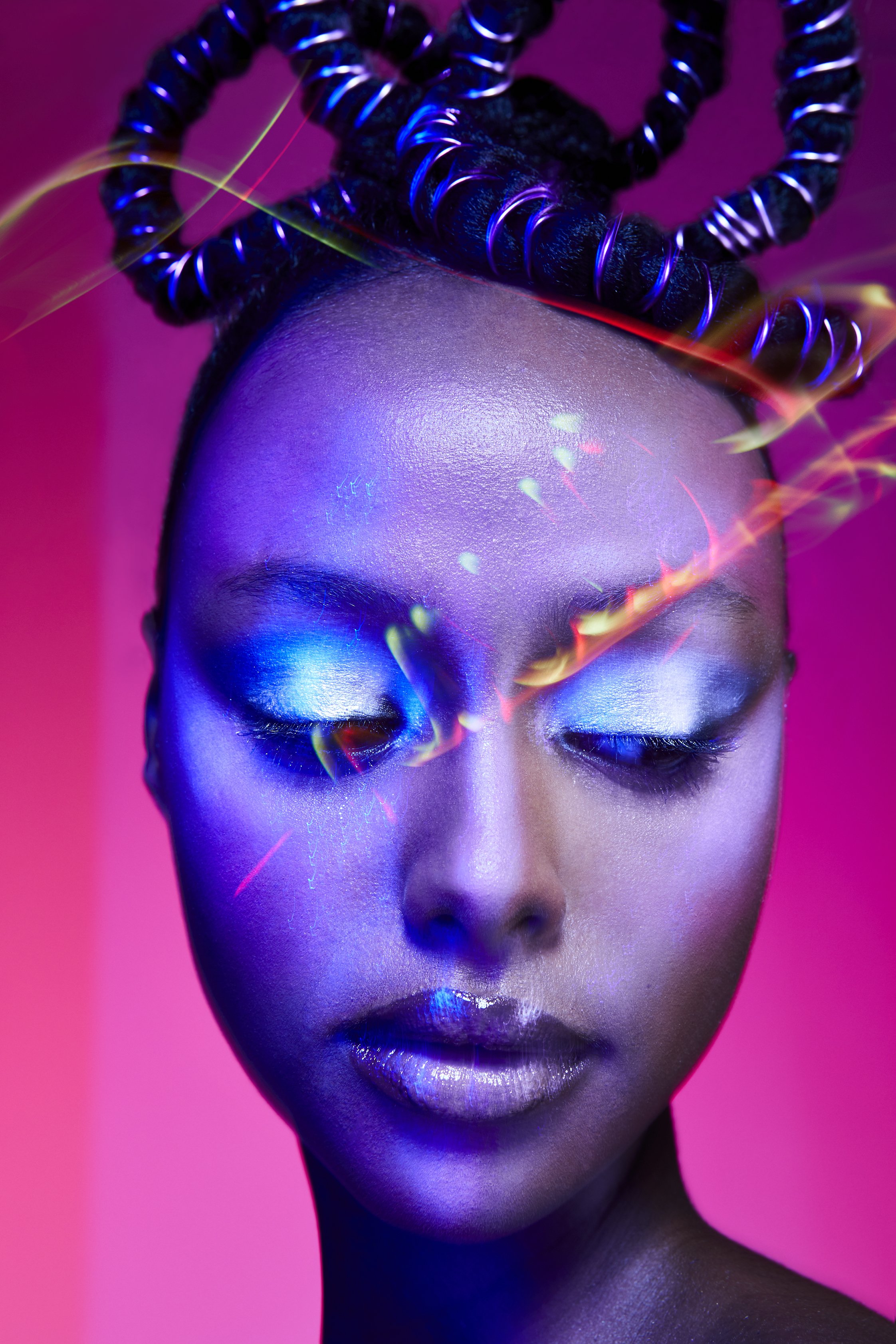 A cropped beauty image of a female model with silver makeup and pink background 