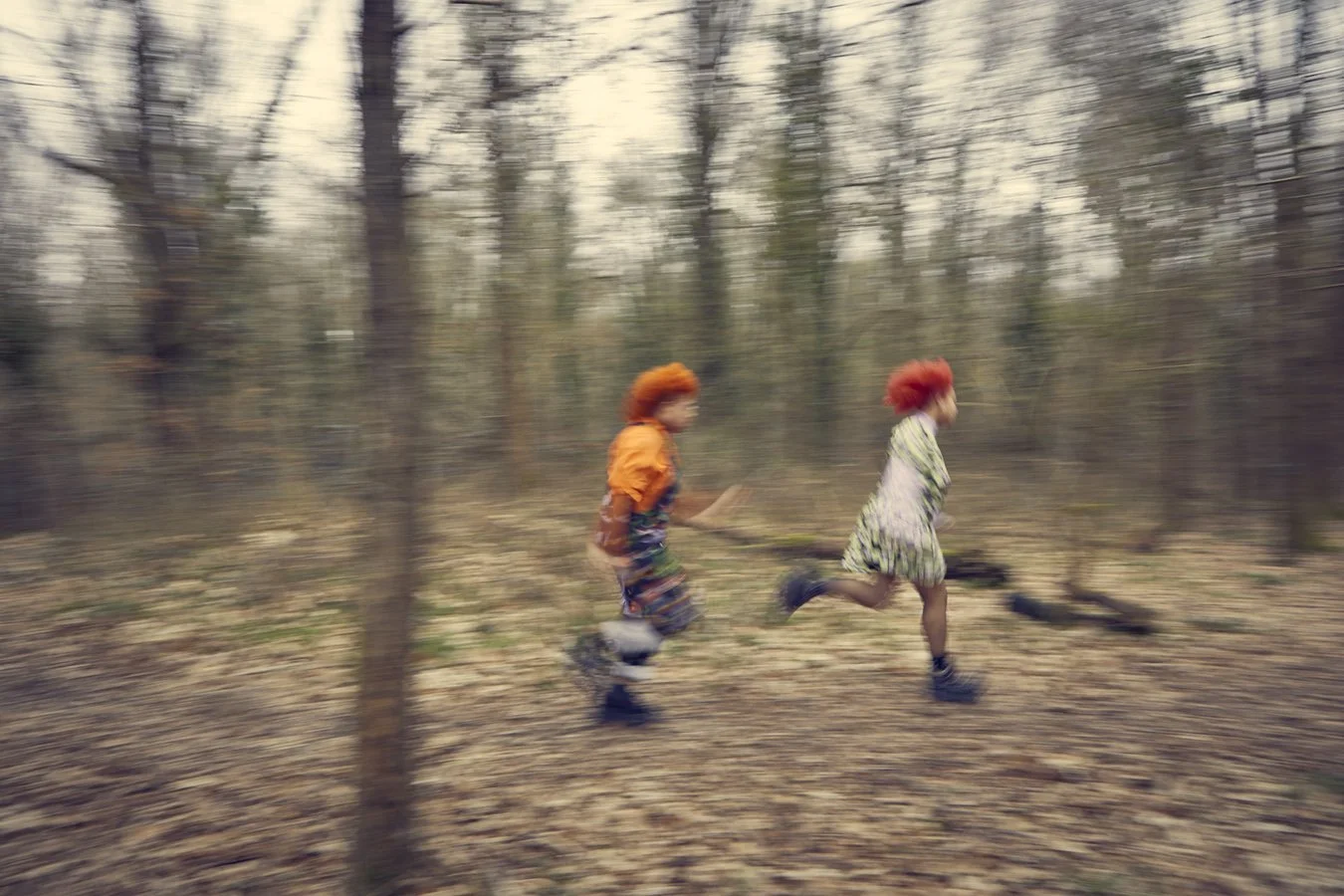 blurred portrait of sisters running in the forrest