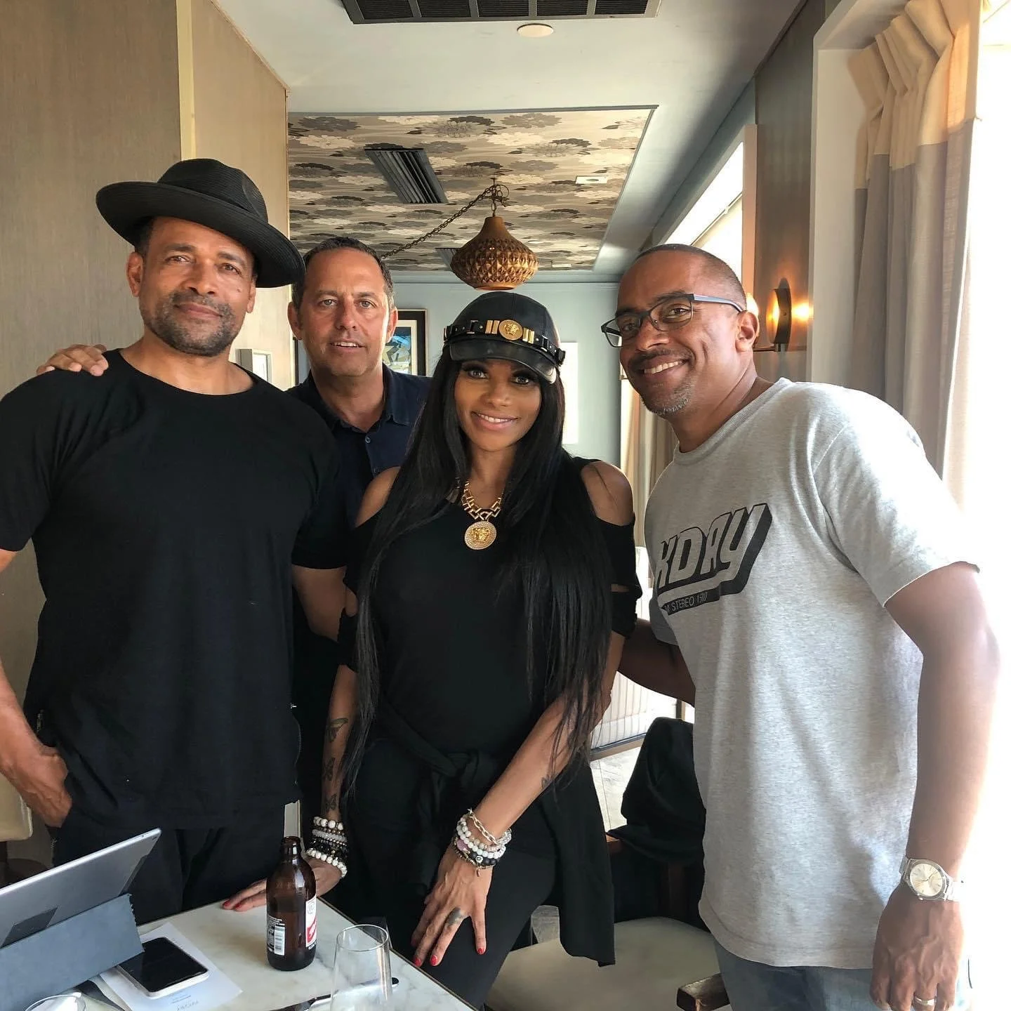 Four people standing together in a room, smiling at the camera.