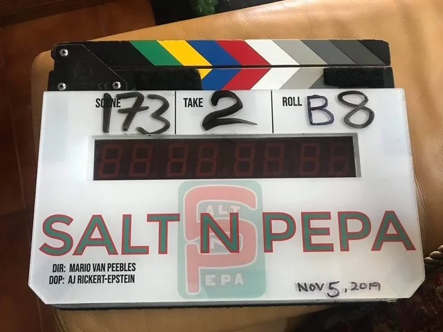Clapperboard and a whiteboard with handwritten numbers 173, 2, and B8 on it.