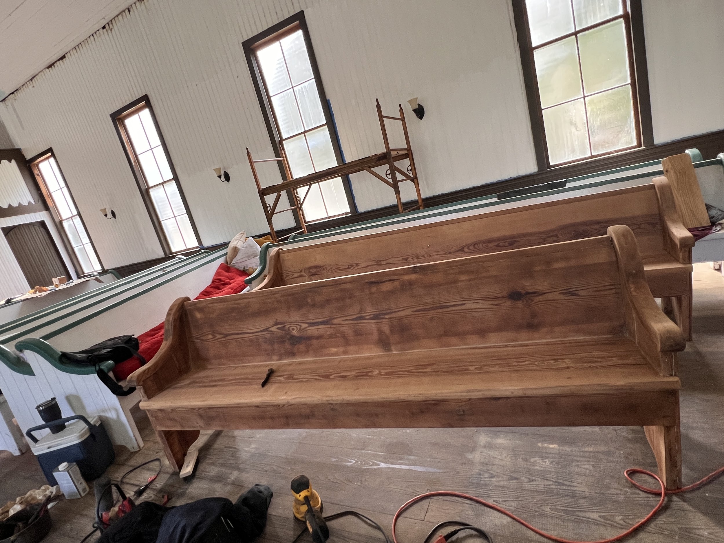 Detail finish sanding of pews in process