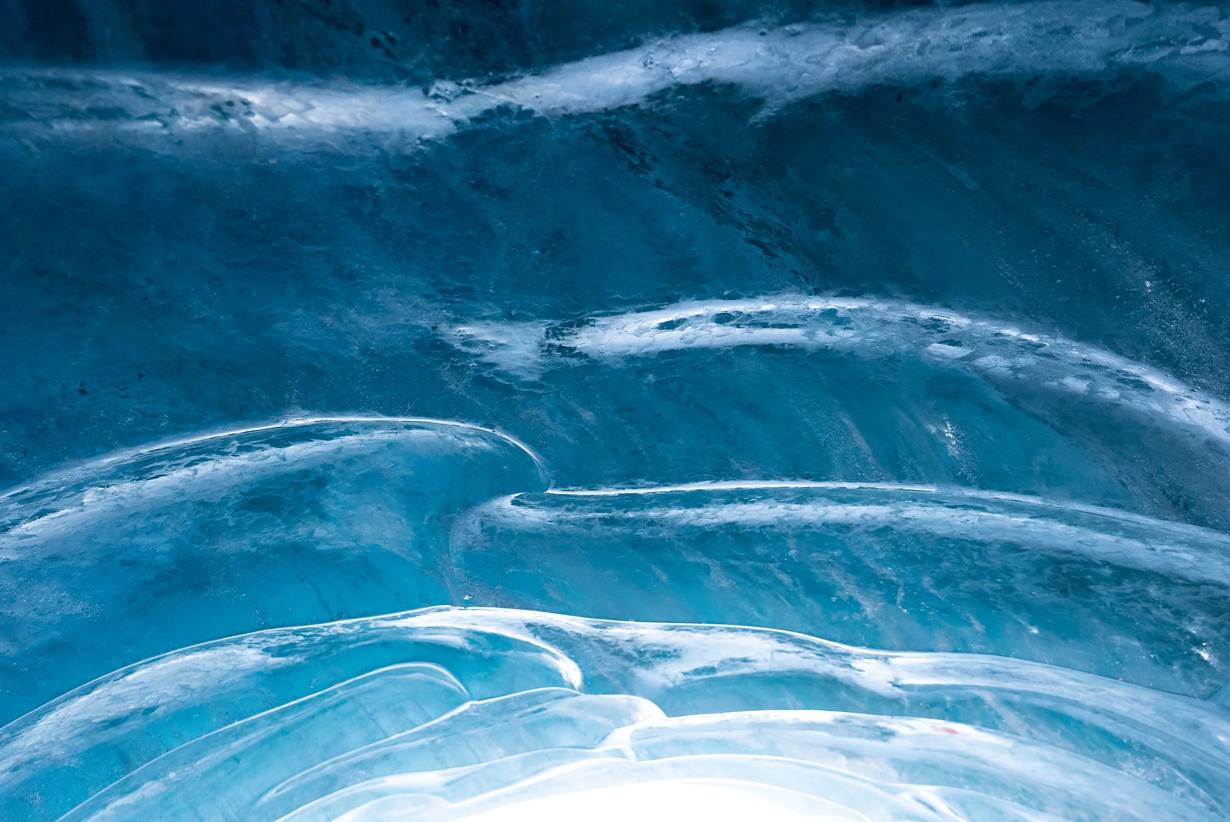 Close-up of a large, crashing ocean wave with shades of blue and white foam.