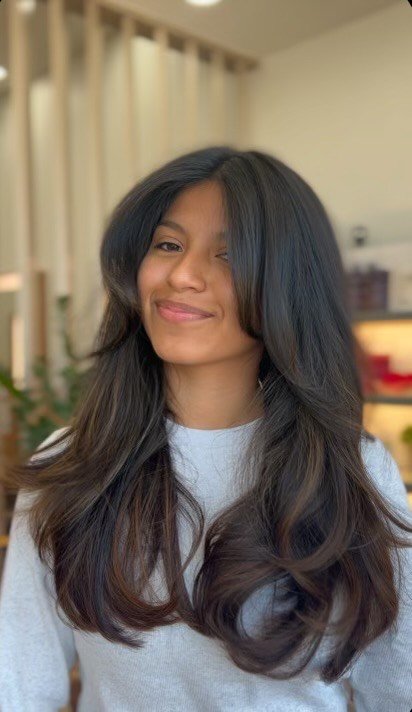 Showcasing a long layered haircut with soft movement and shine, this look highlights Davanti Salon’s expertise in creating effortless, face-framing styles that complement natural texture and enhance everyday wearability.
