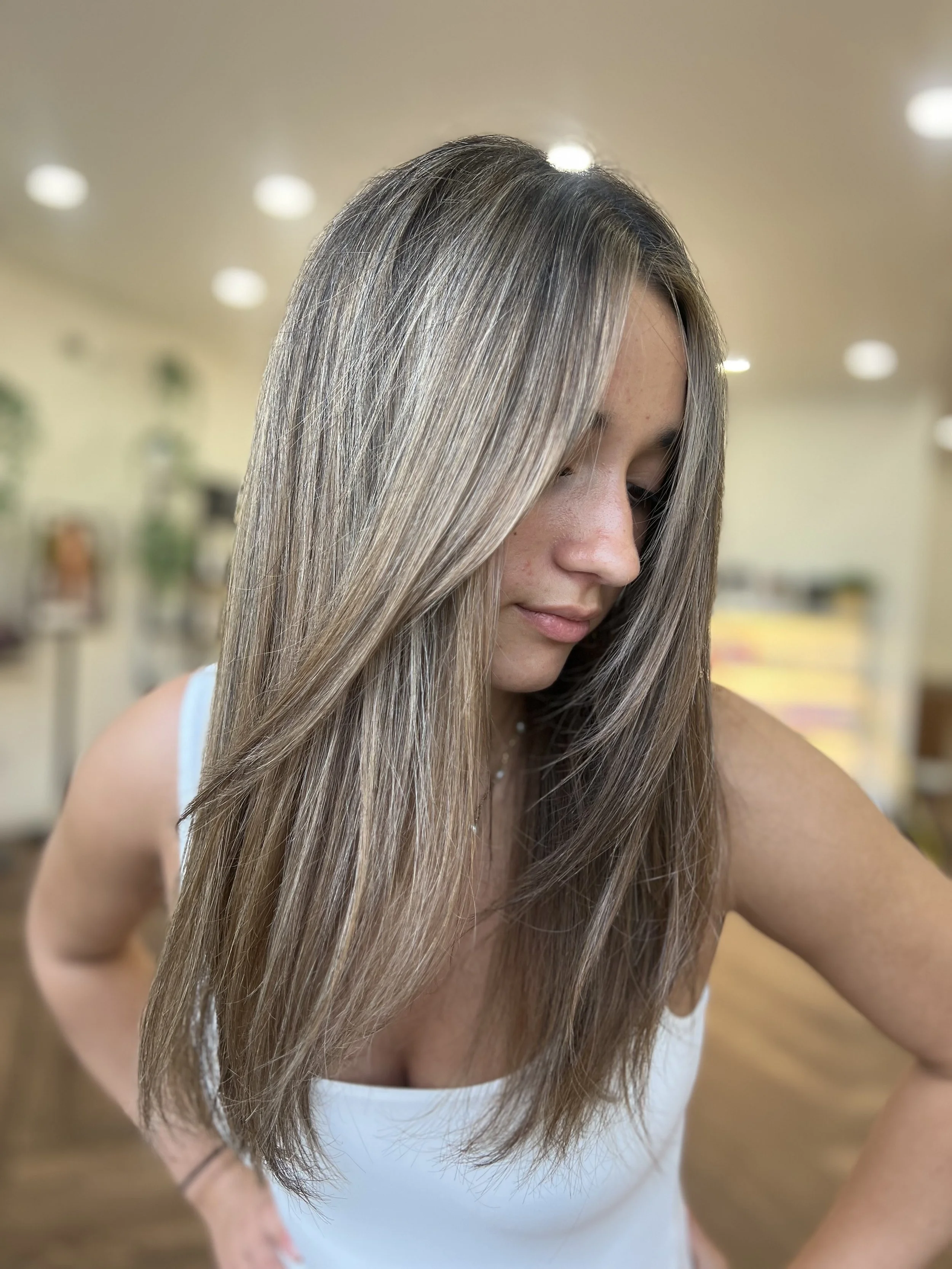 A modern highlighted brunette look with soft blonde dimension and face-framing long layers. Styled sleek and smooth, this service showcases Davanti Salon’s expertise in creating natural, low-maintenance color with maximum shine.