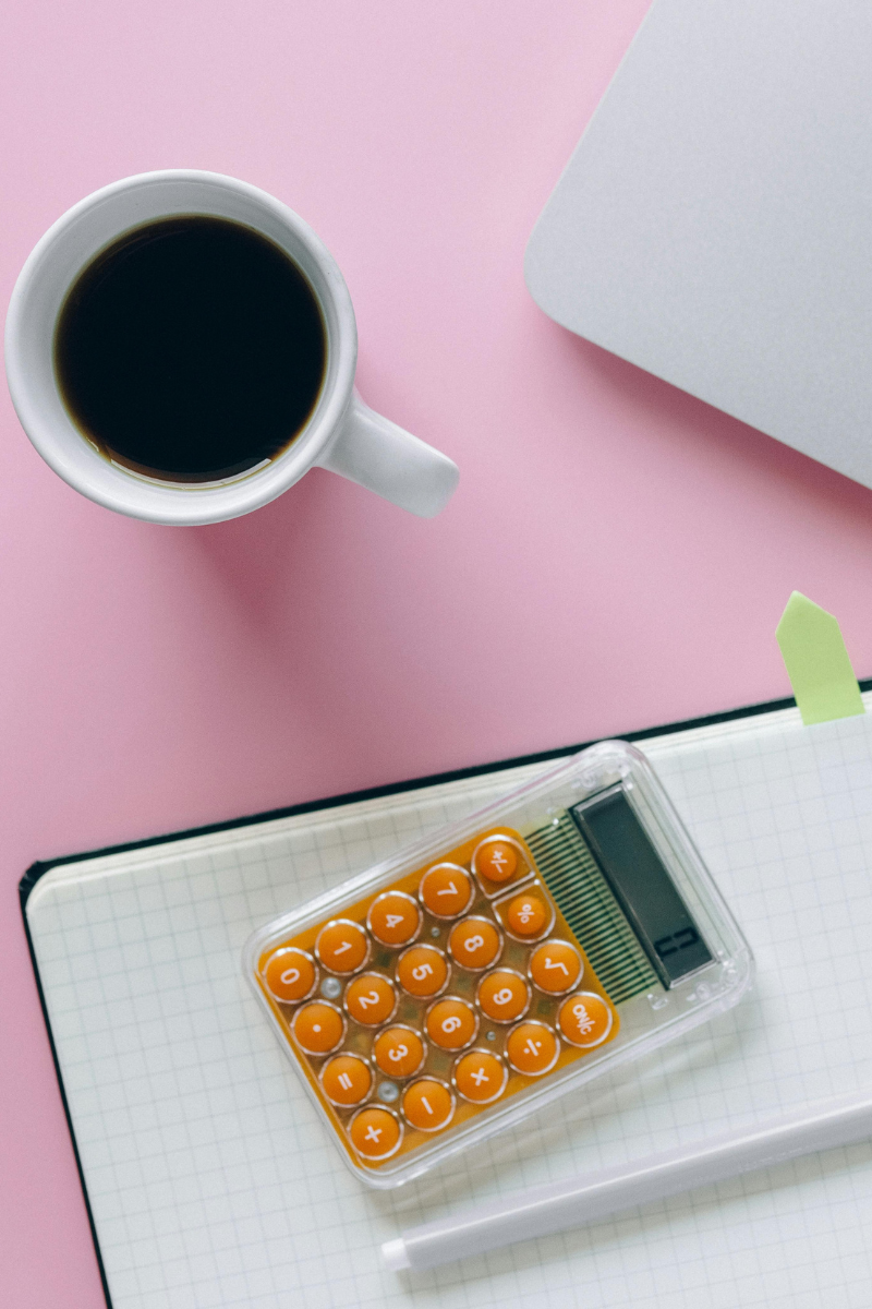 Notebook, calculator and coffee on a kitchen table while planning a first home purchase with North Carolina down payment assistance