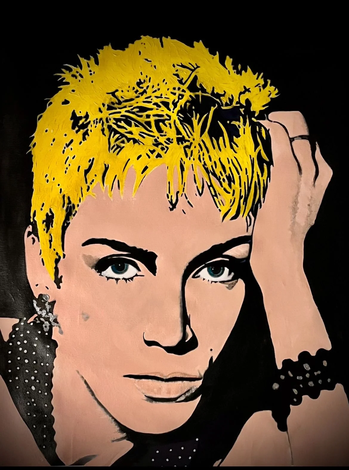 Pop art portrait of a woman with short yellow hair, wearing earrings and a polka dot top, with a black background.