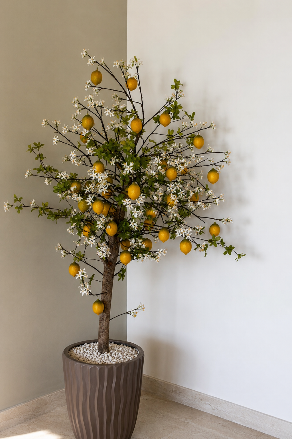 Artificial lemonTree with white blossoms in a decorative large brown pot placed indoors.