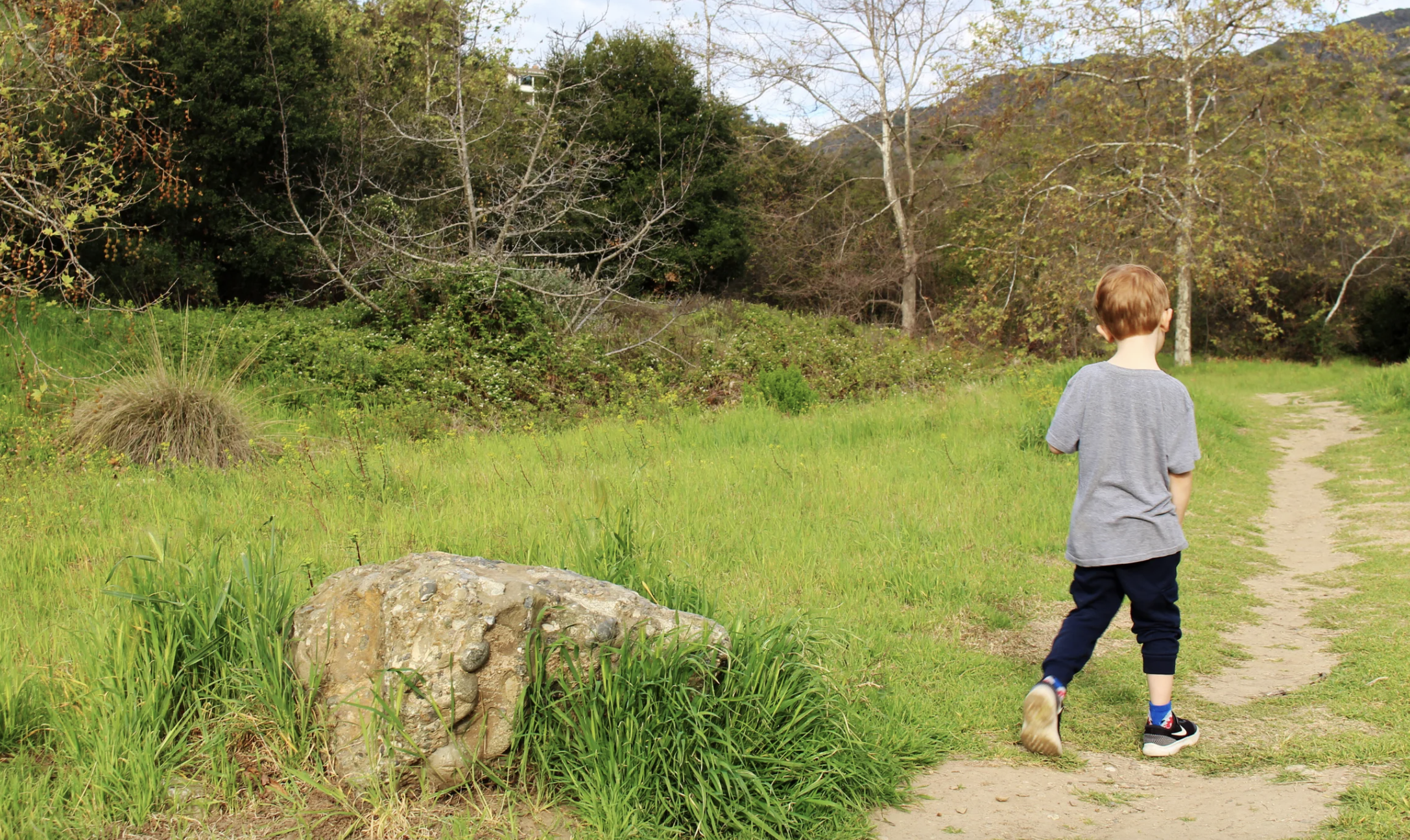 A little boy walks on a trail