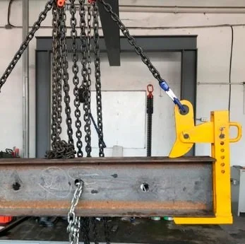 Equipo de seguridad con cadenas y una estructura metálica amarilla en un taller.